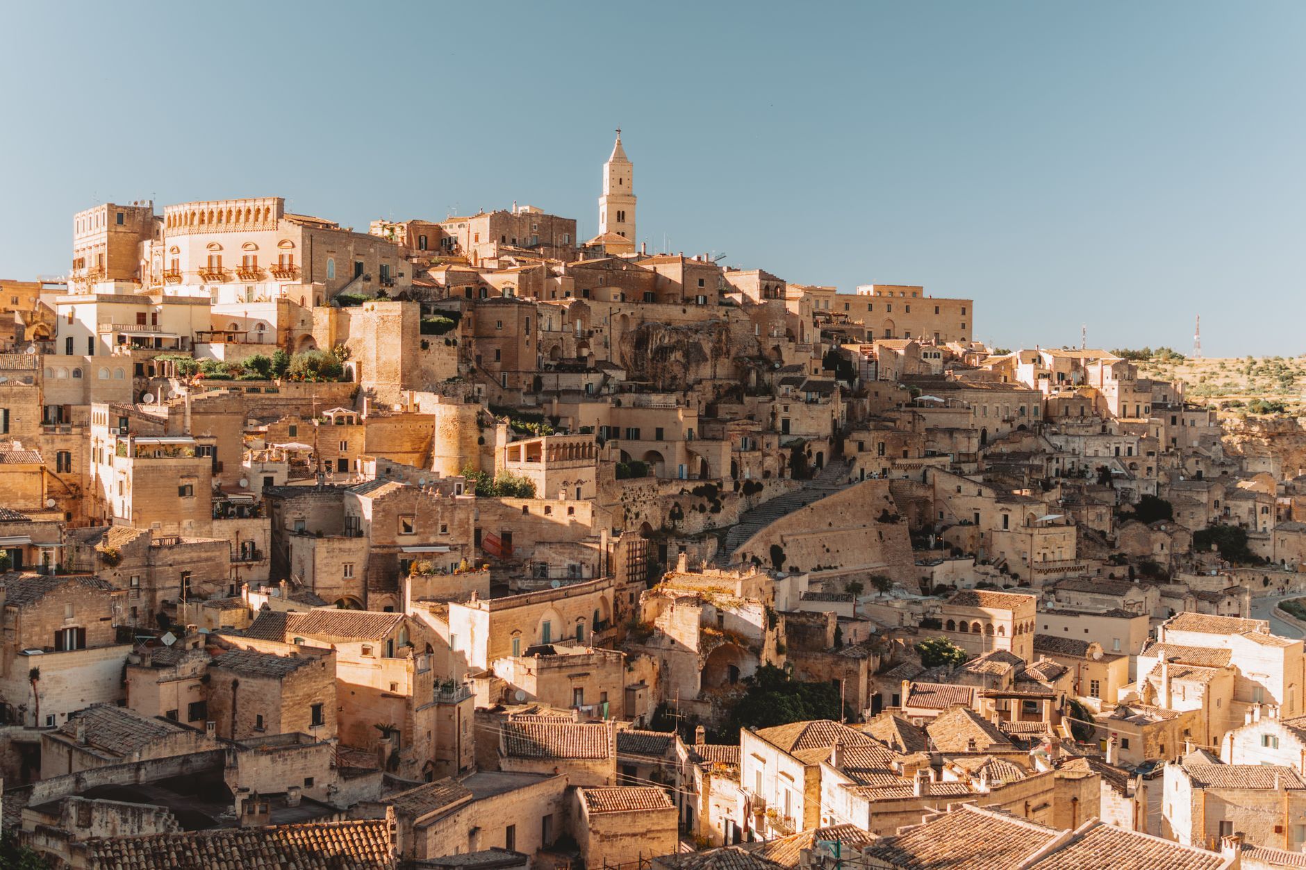 Explore the ancient stone dwellings of Matera, Italy, a UNESCO World Heritage site bathed in golden light.