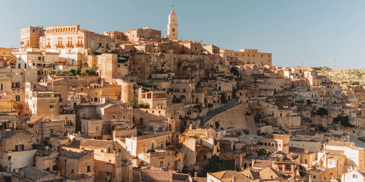 Explore the ancient stone dwellings of Matera, Italy, a UNESCO World Heritage site bathed in golden light.