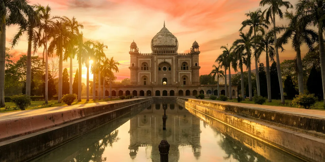 Breathtaking view of Safdarjung Tomb reflecting in the water at sunset in New Delhi, India.