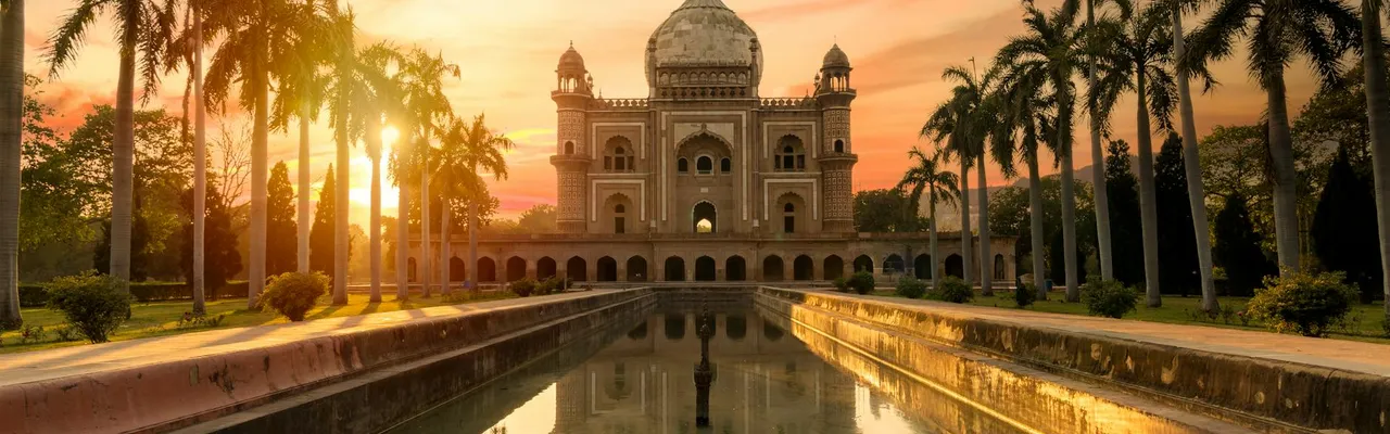 Breathtaking view of Safdarjung Tomb reflecting in the water at sunset in New Delhi, India.