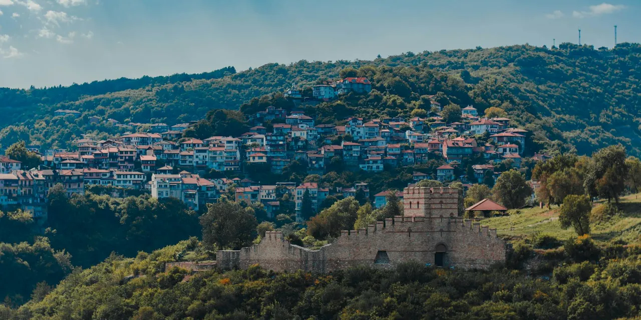 A stunning aerial view of Veliko Tarnovo, Bulgaria, showcasing a historic fortress and vibrant hillside houses.