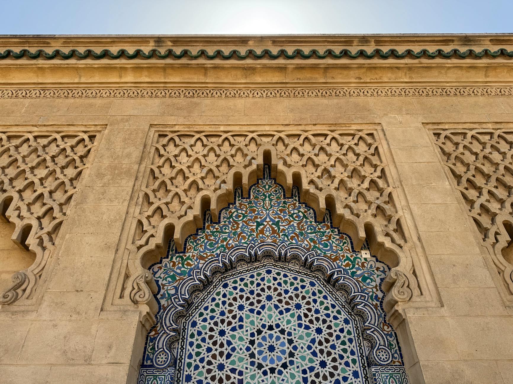 Intricate Moroccan tilework and stone carving in a traditional architectural design.