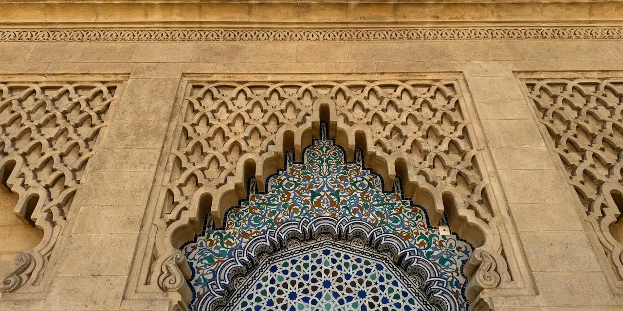 Intricate Moroccan tilework and stone carving in a traditional architectural design.