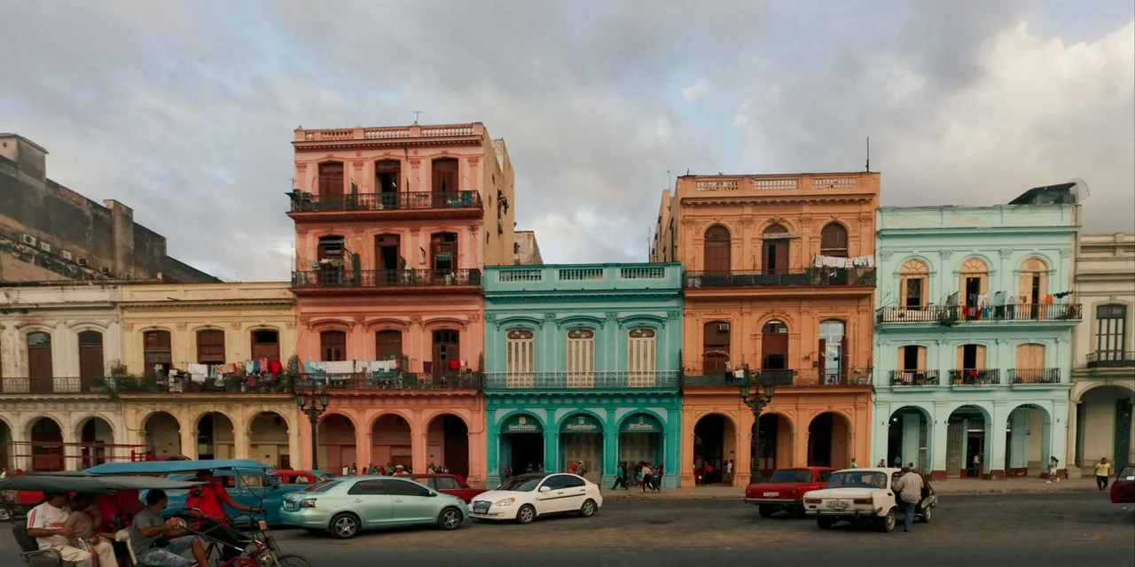 Charming vintage architecture with tricycles and cars in Old Havana, Cuba.