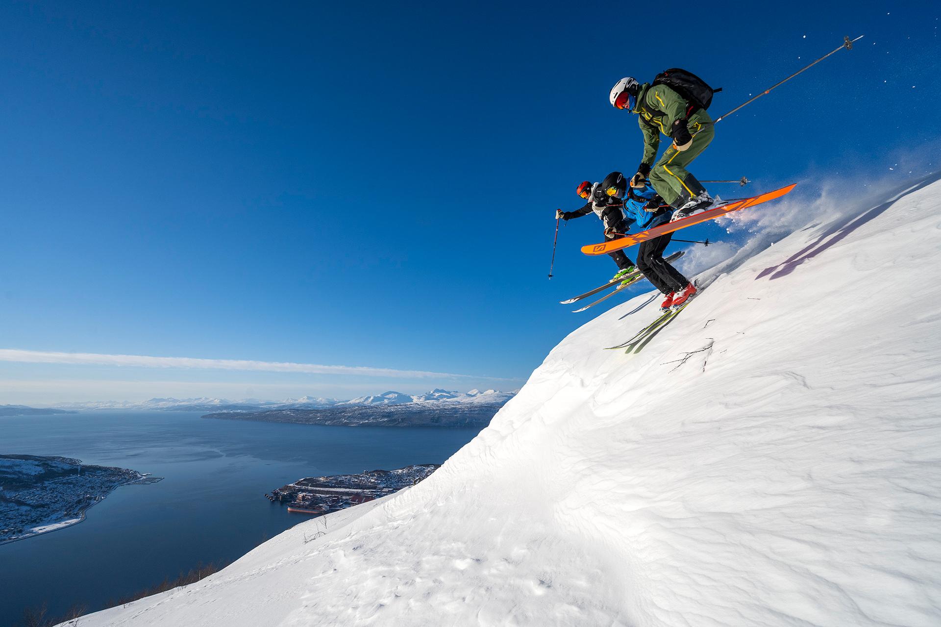 Skikjørere i Narvikfjellet med utsikt over fjorden