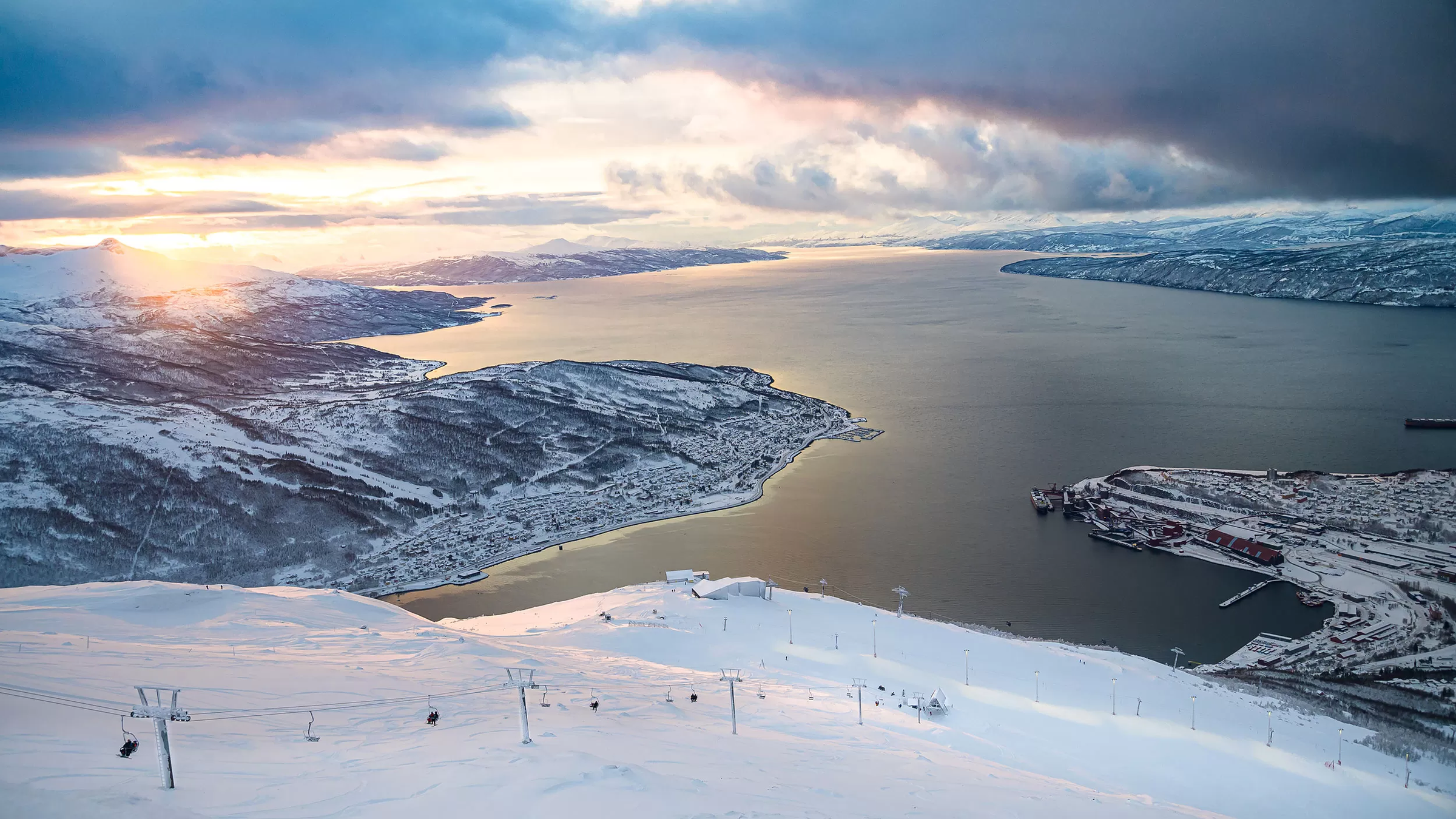 Utsikt fra toppen av Narvikfjellet over byen og fjorden i vinterlys.