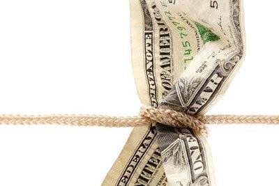 Dollar bill tied with string, representing stretching a budget.