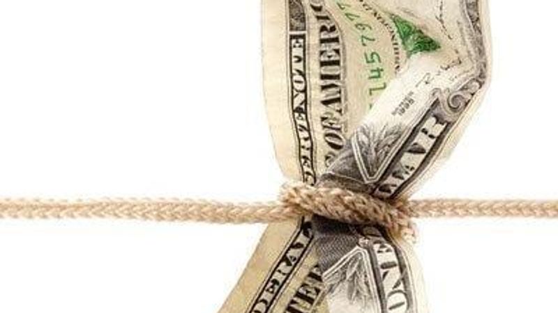Dollar bill tied with string, representing stretching a budget.