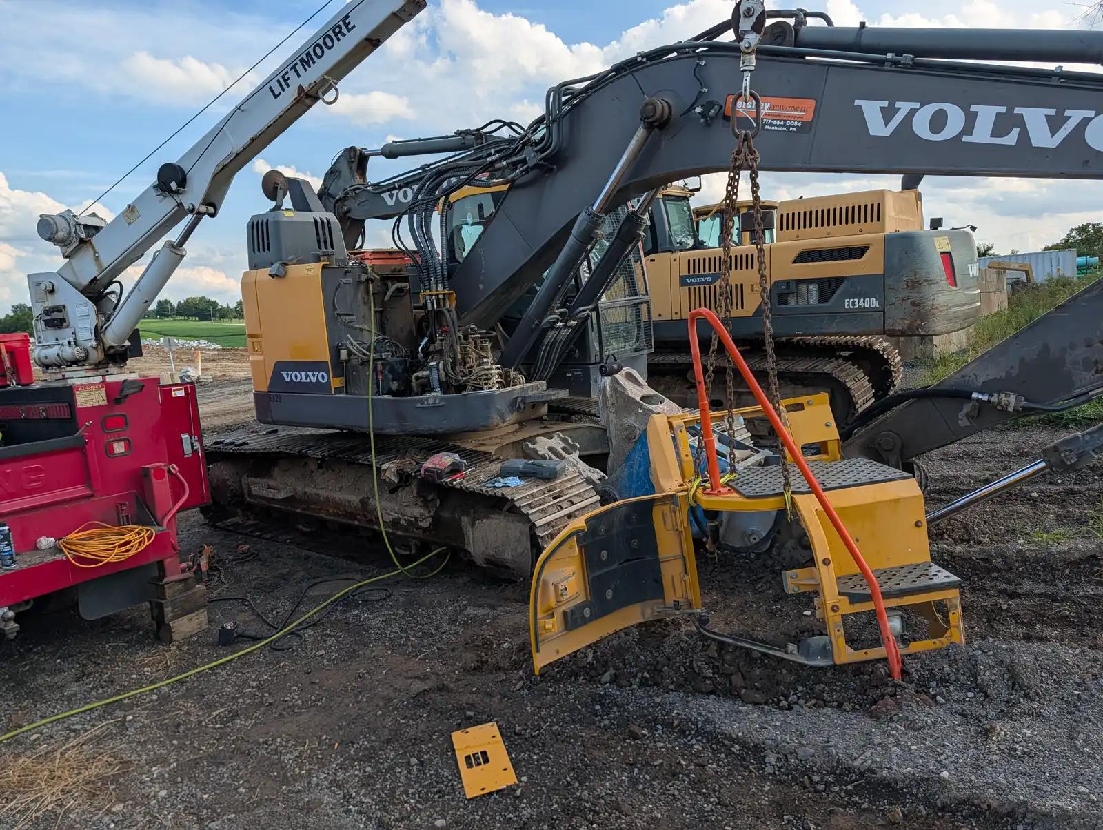 Excavator with lifting equipment during truck and heavy equipment service