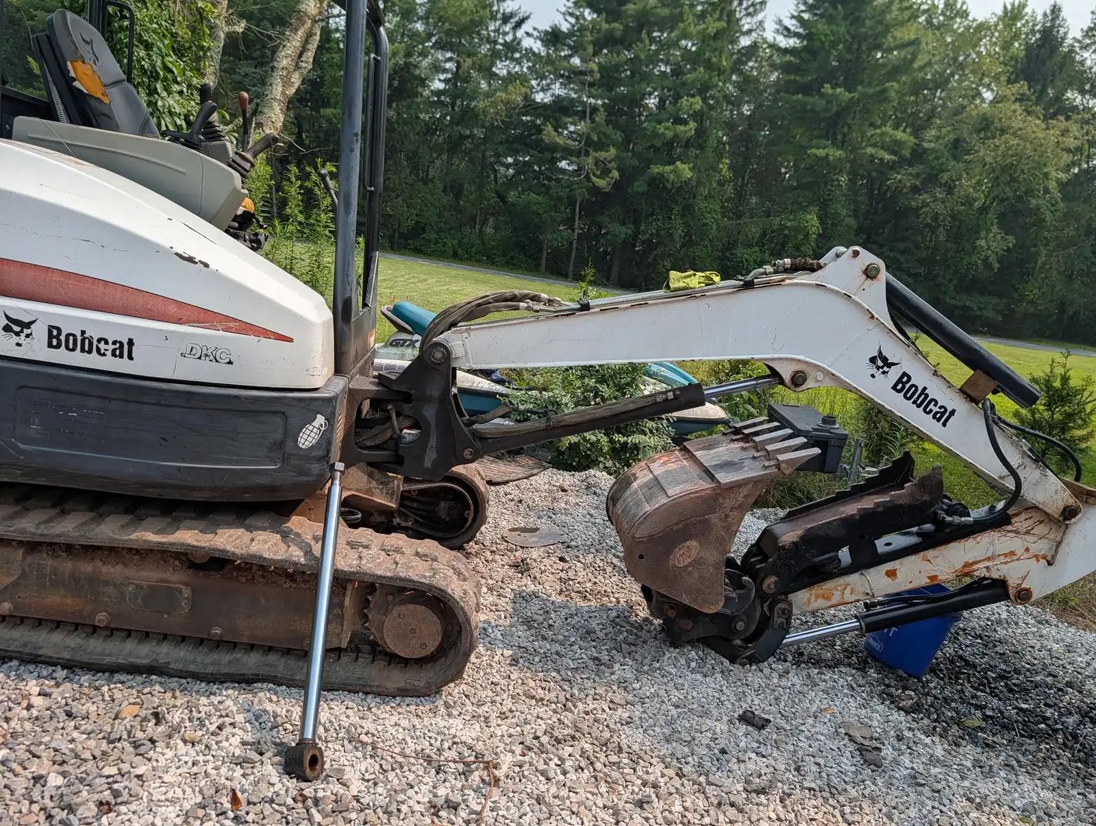 Compact excavator at the job site during truck and heavy equipment service