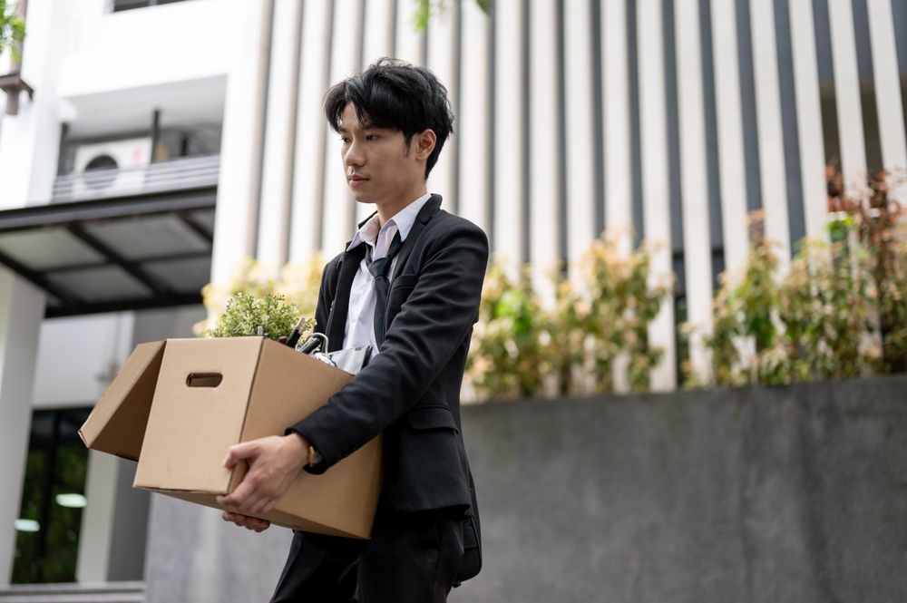 Young professional carrying a box after job loss, representing employment consequences after a DUI arrest in New Jersey