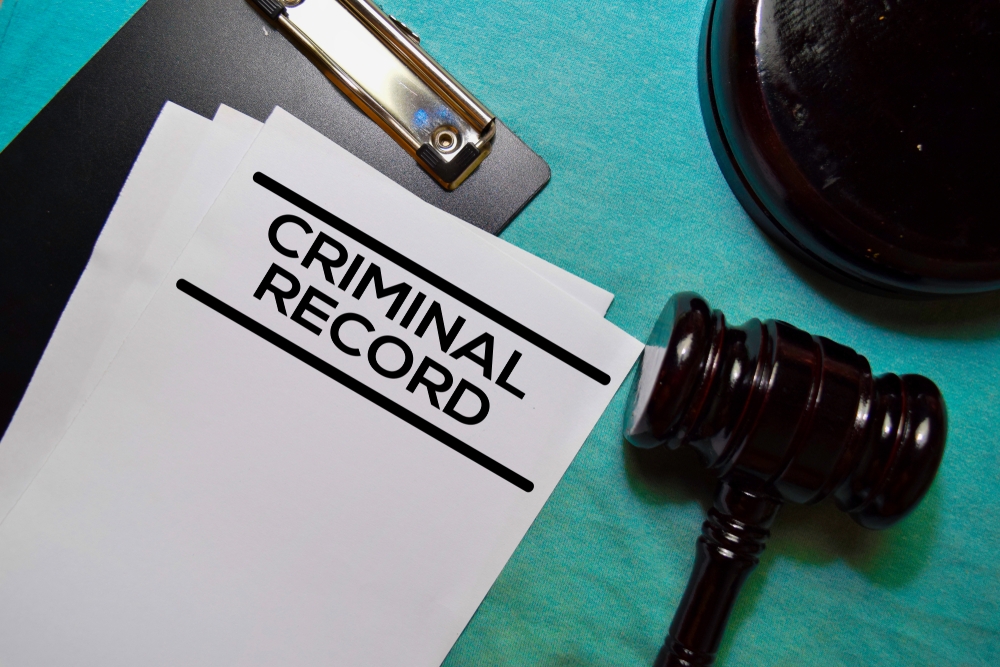 Image A criminal record file next to a judge’s gavel, symbolizing the legal consequences someone may face in New Jersey.