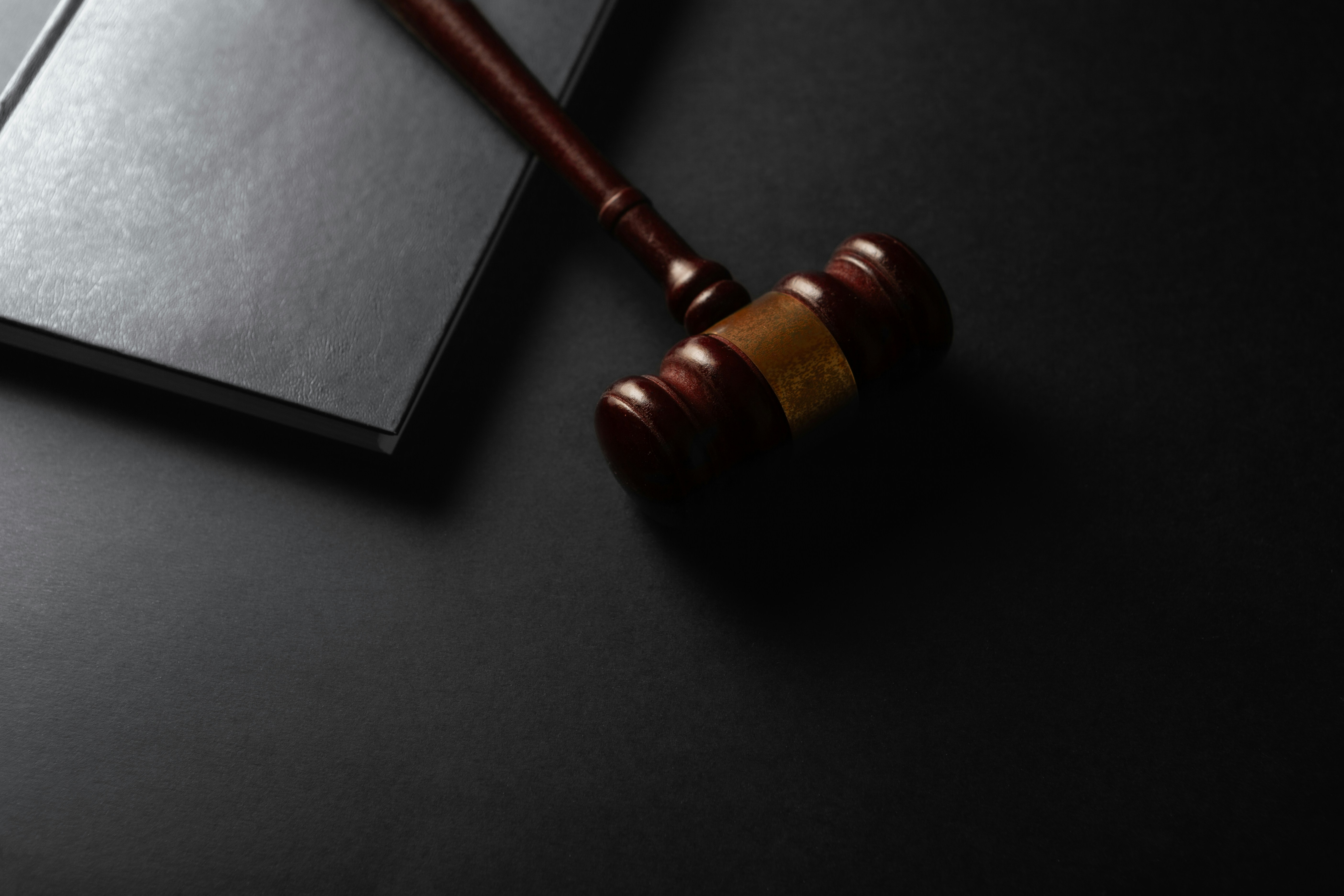 Image Wooden judge's gavel resting on a black law book against a dark background, symbolizing New Jersey wage and hour litigation.