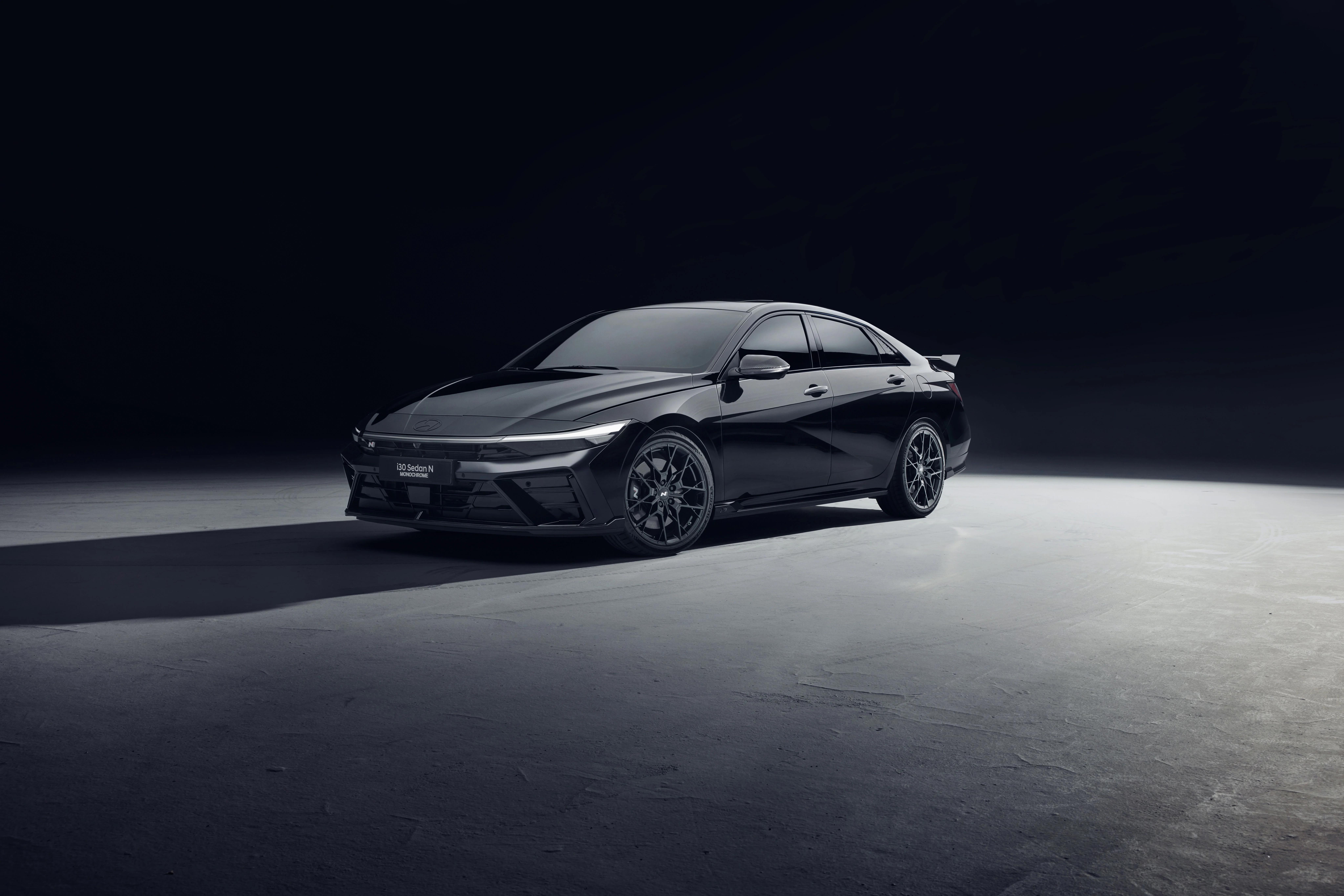 Three-quarter front view of the Hyundai i30 Sedan N MONOCHROME in Abyss Black Pearl