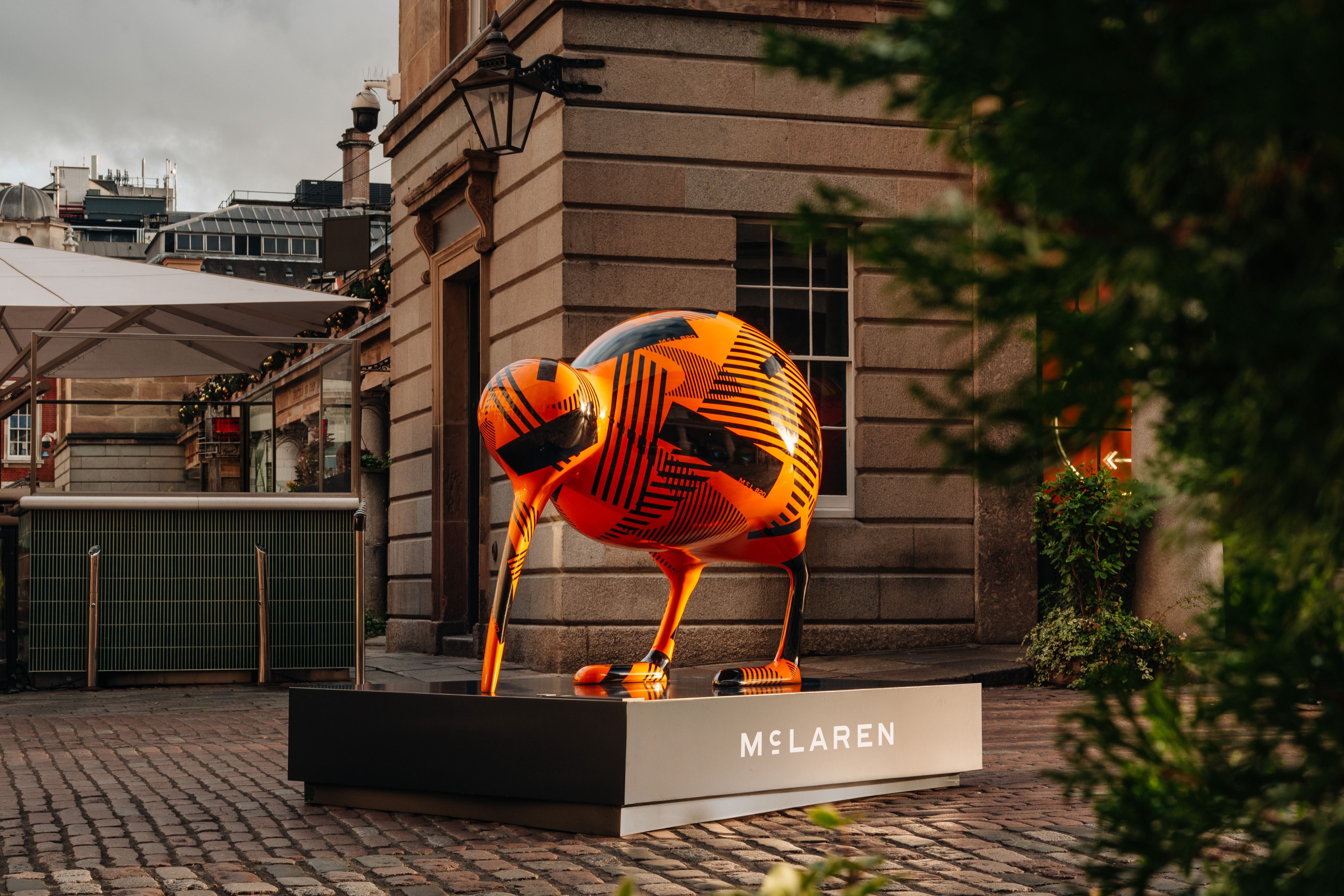 Camouflaged McLaren kiwi statue in London bearing the McL 820 name