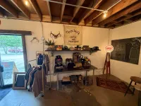 Inside Moon Wolf Provisions at 920 Custer Rd, Richardson TX — the Den interior wide-angle showing the Moon Wolf banner, merch wall, exposed beams, and APCO sign on opening week