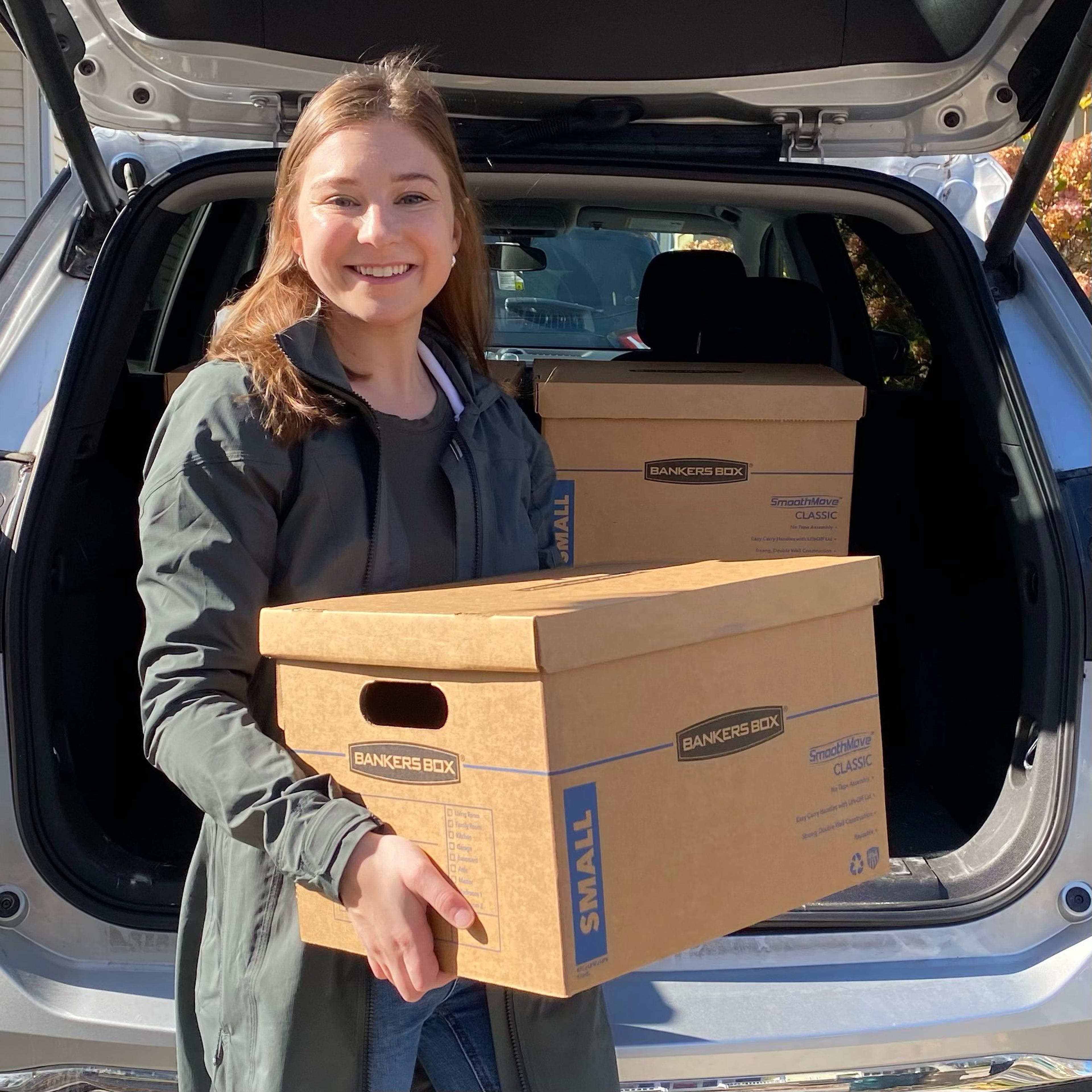 Mia volunteering putting school supplies in a box