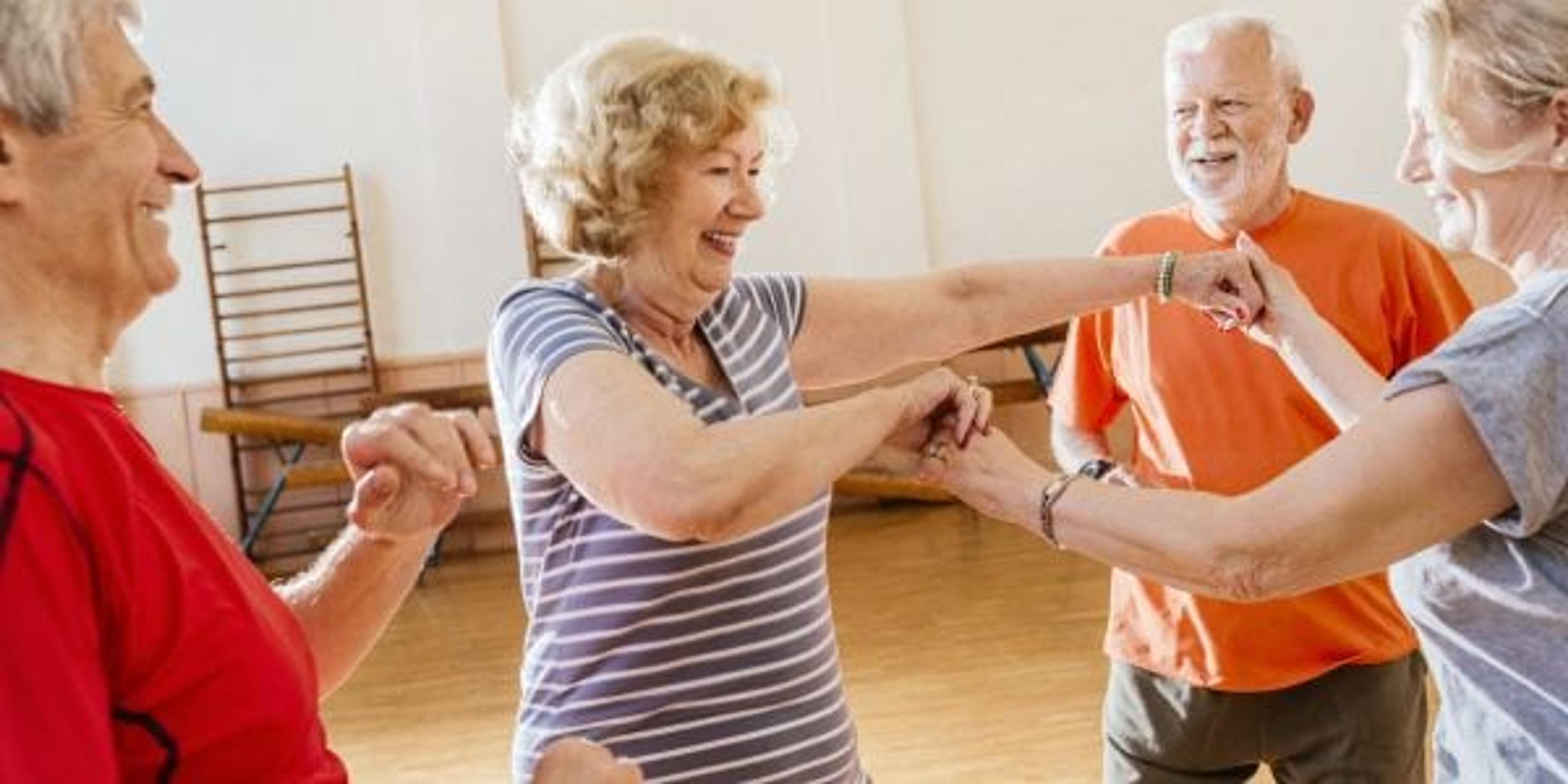 playful seniors having fun together and dancing