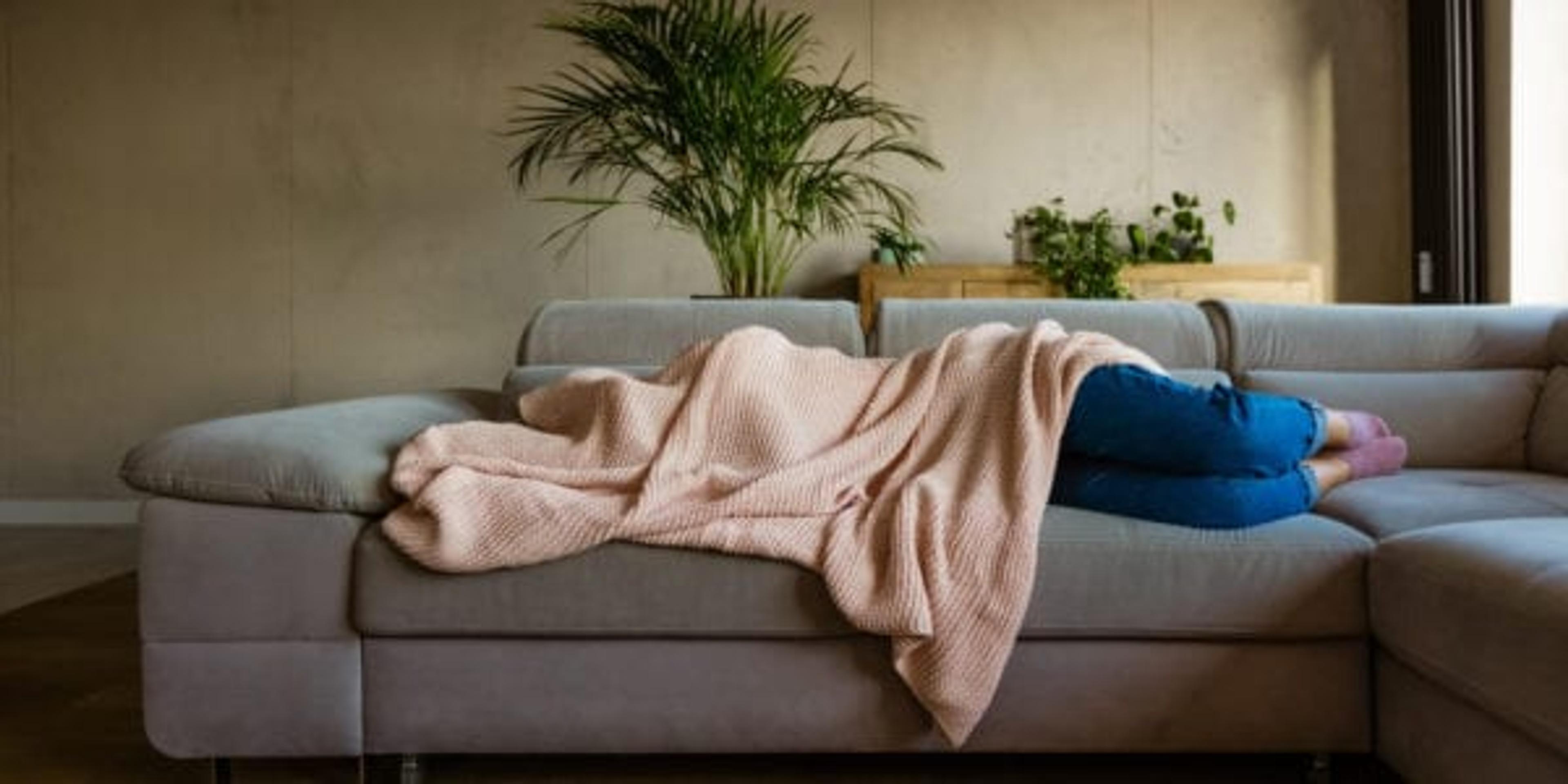 Young woman sleeping under blanket