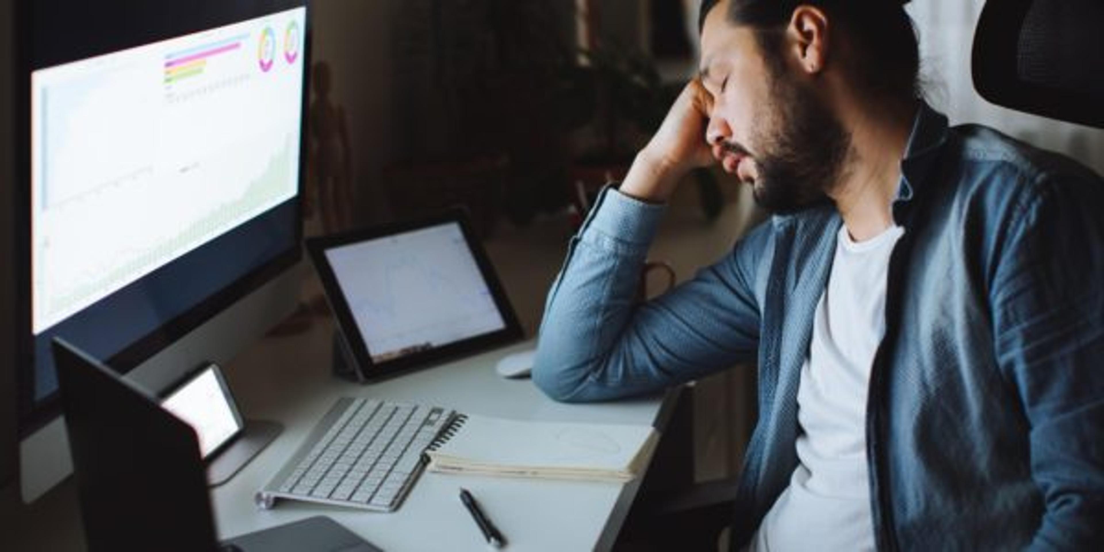 Young man using desktop pc at desk in home office