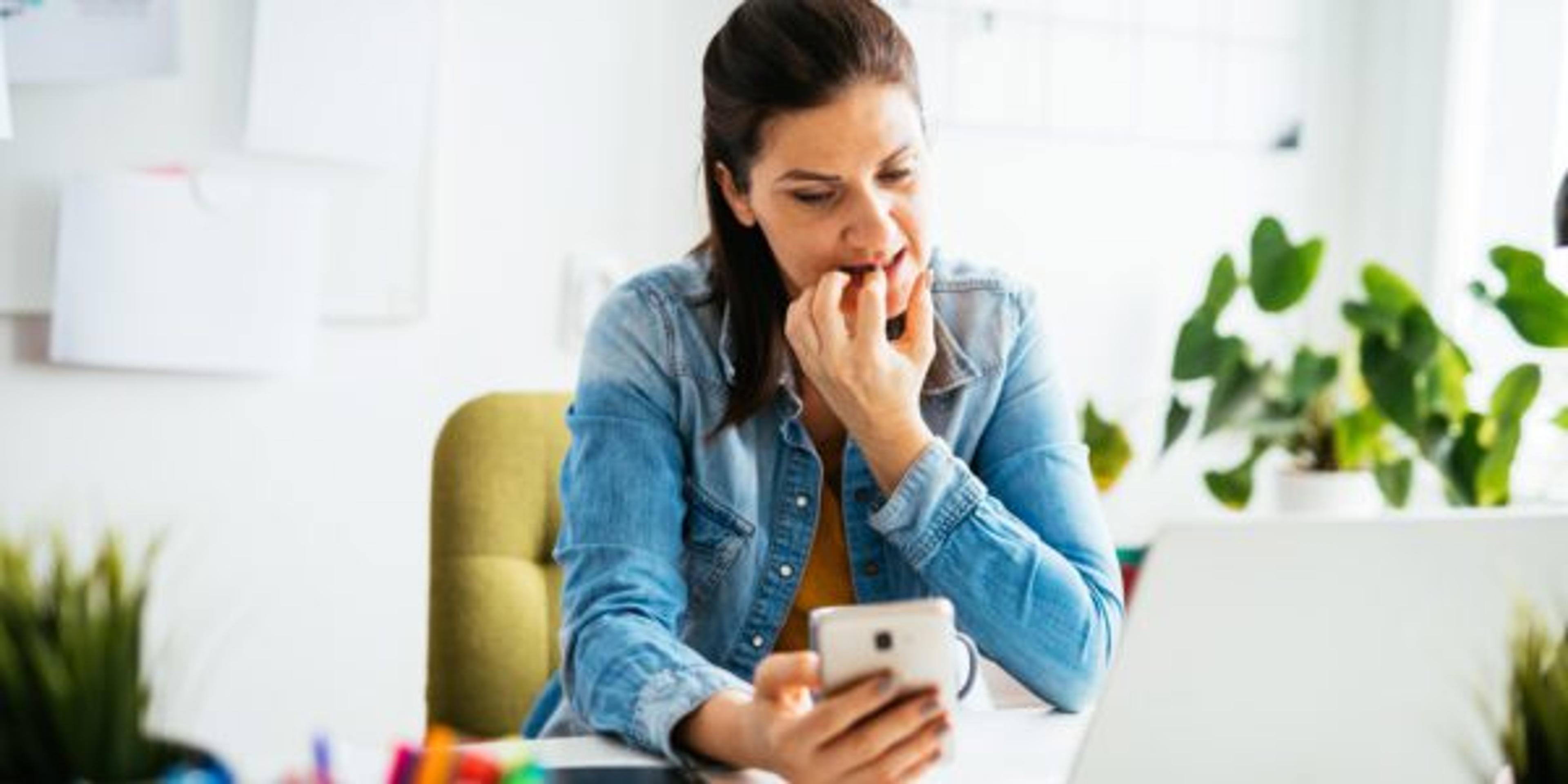 Woman working on laptop and smartphone