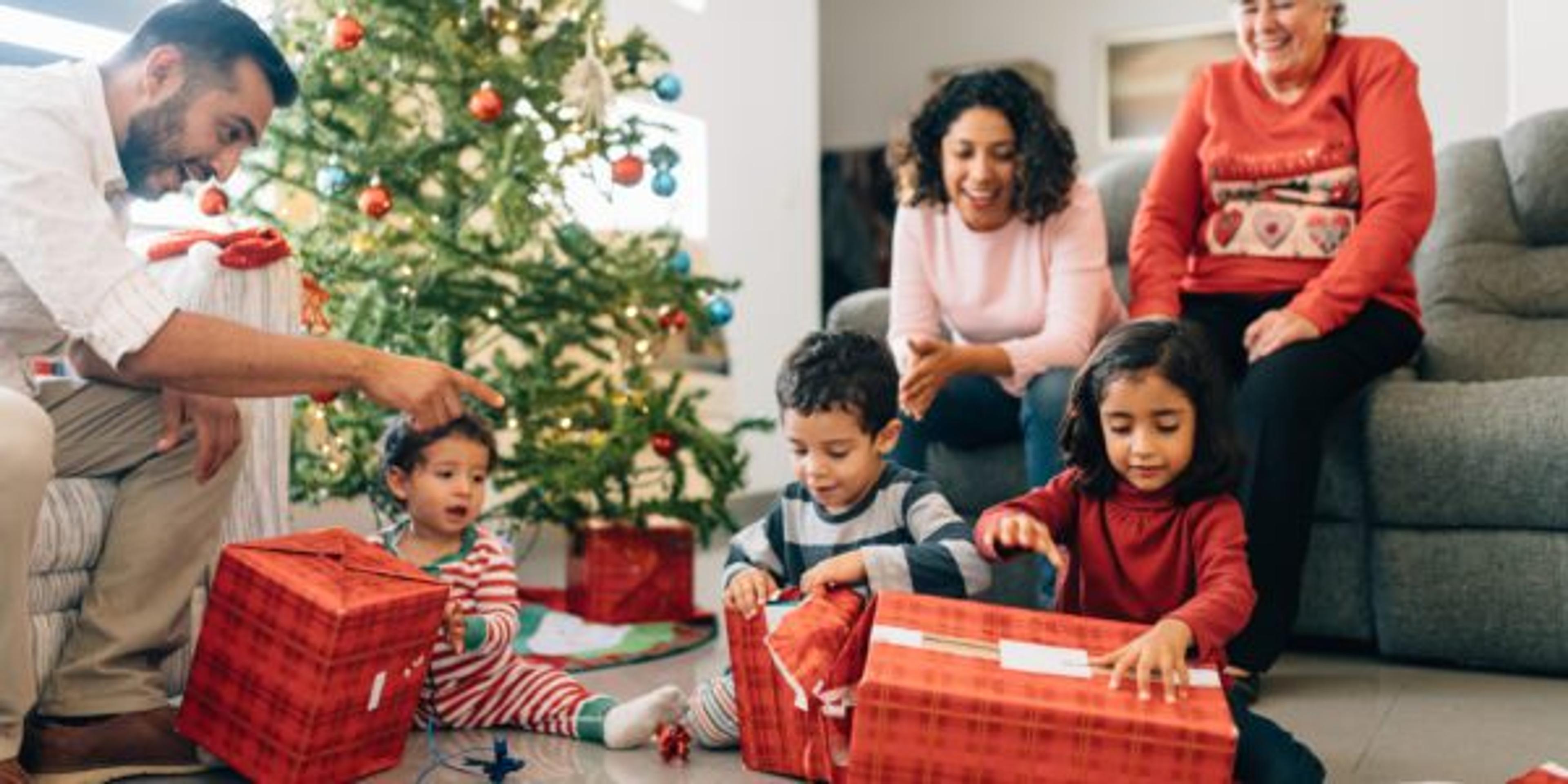 Family opens gifts for children and babies on Christmas morning