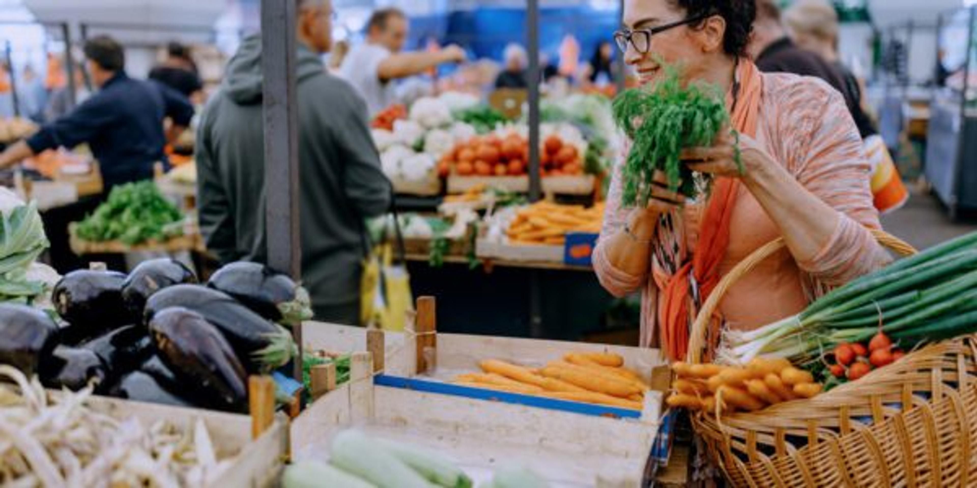 A woman excitedly explores her local farmers market.