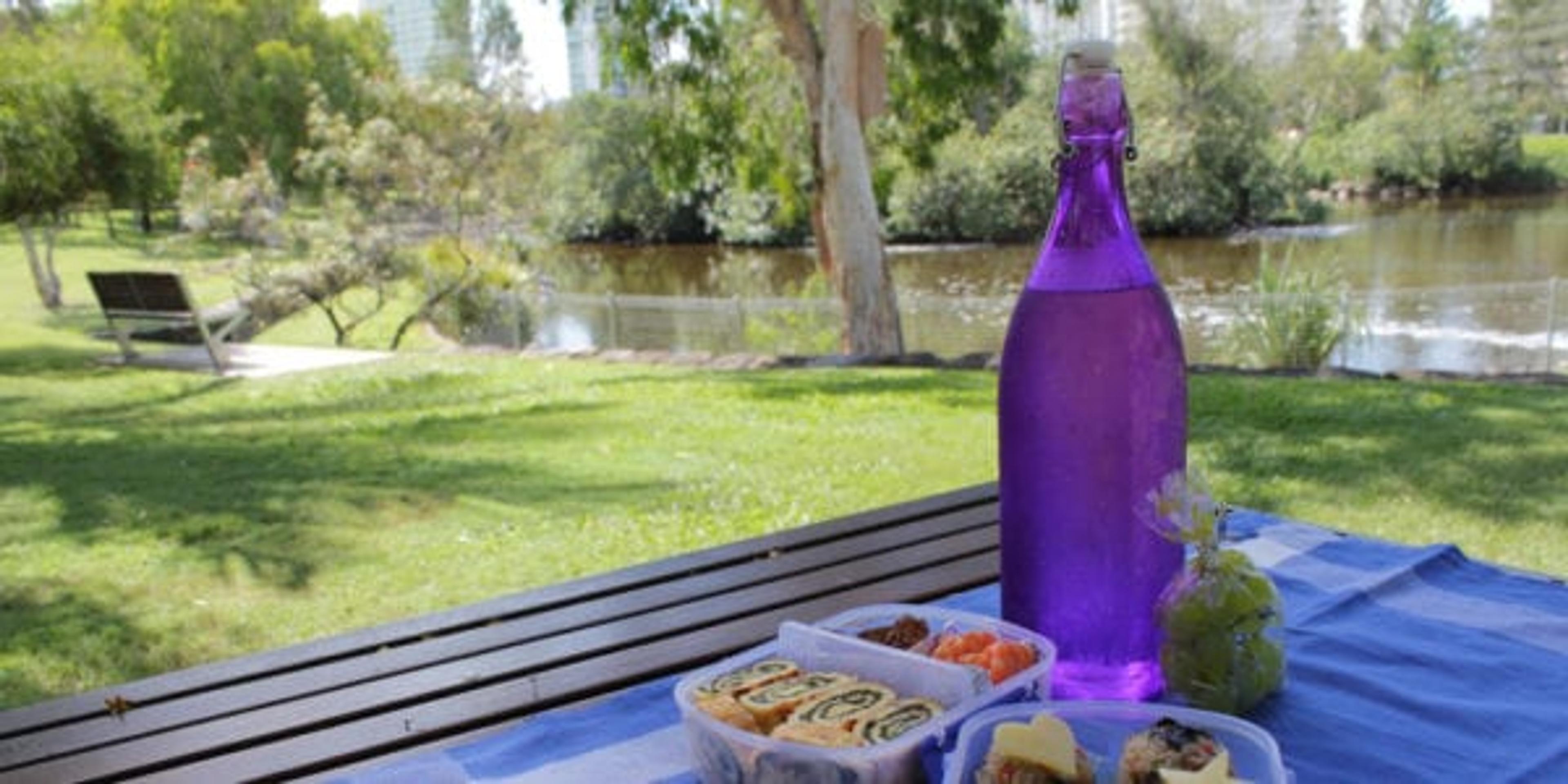 Water and food on a picnic table.