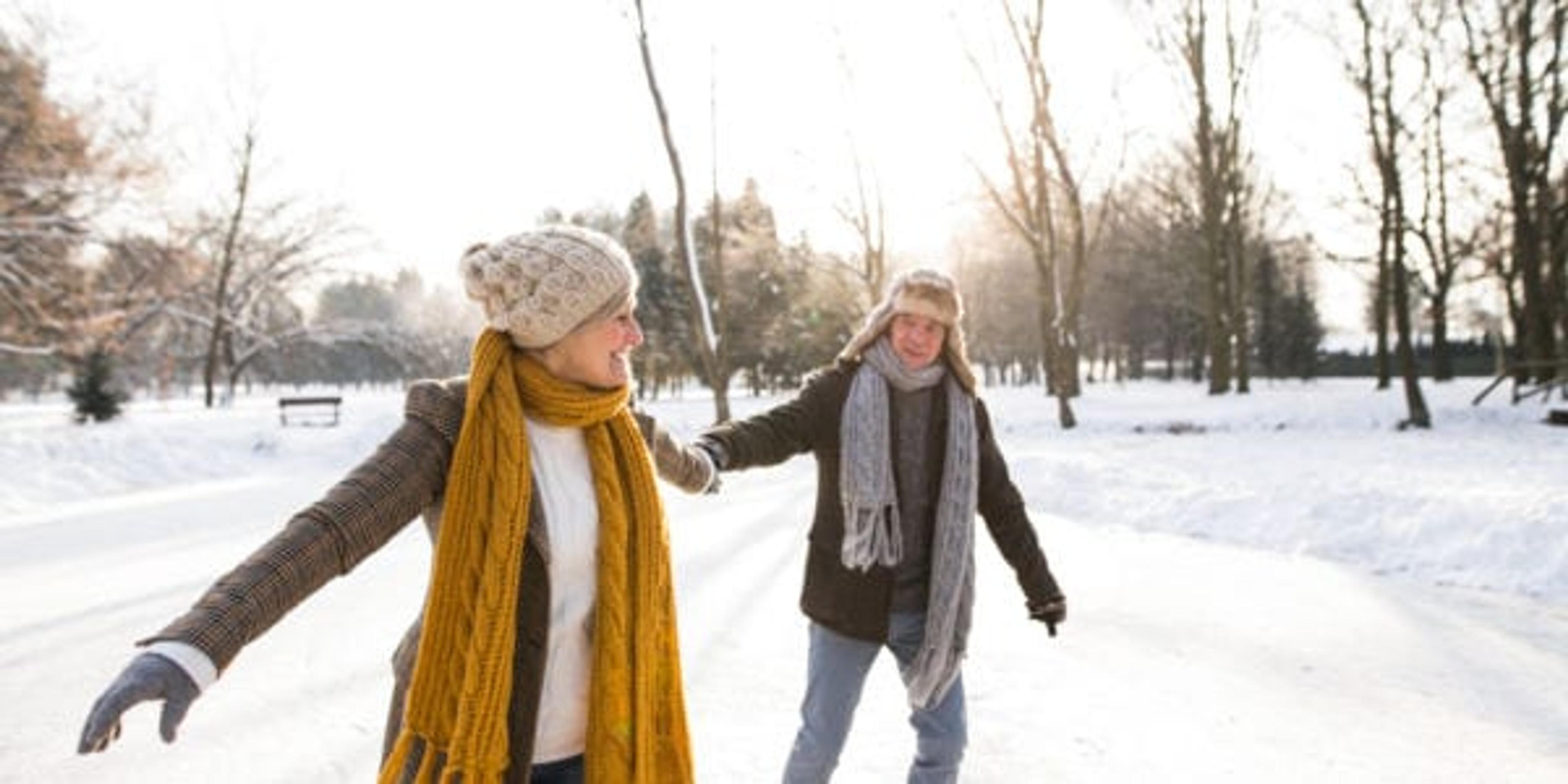 Senior couple ice skating in the sunshine.