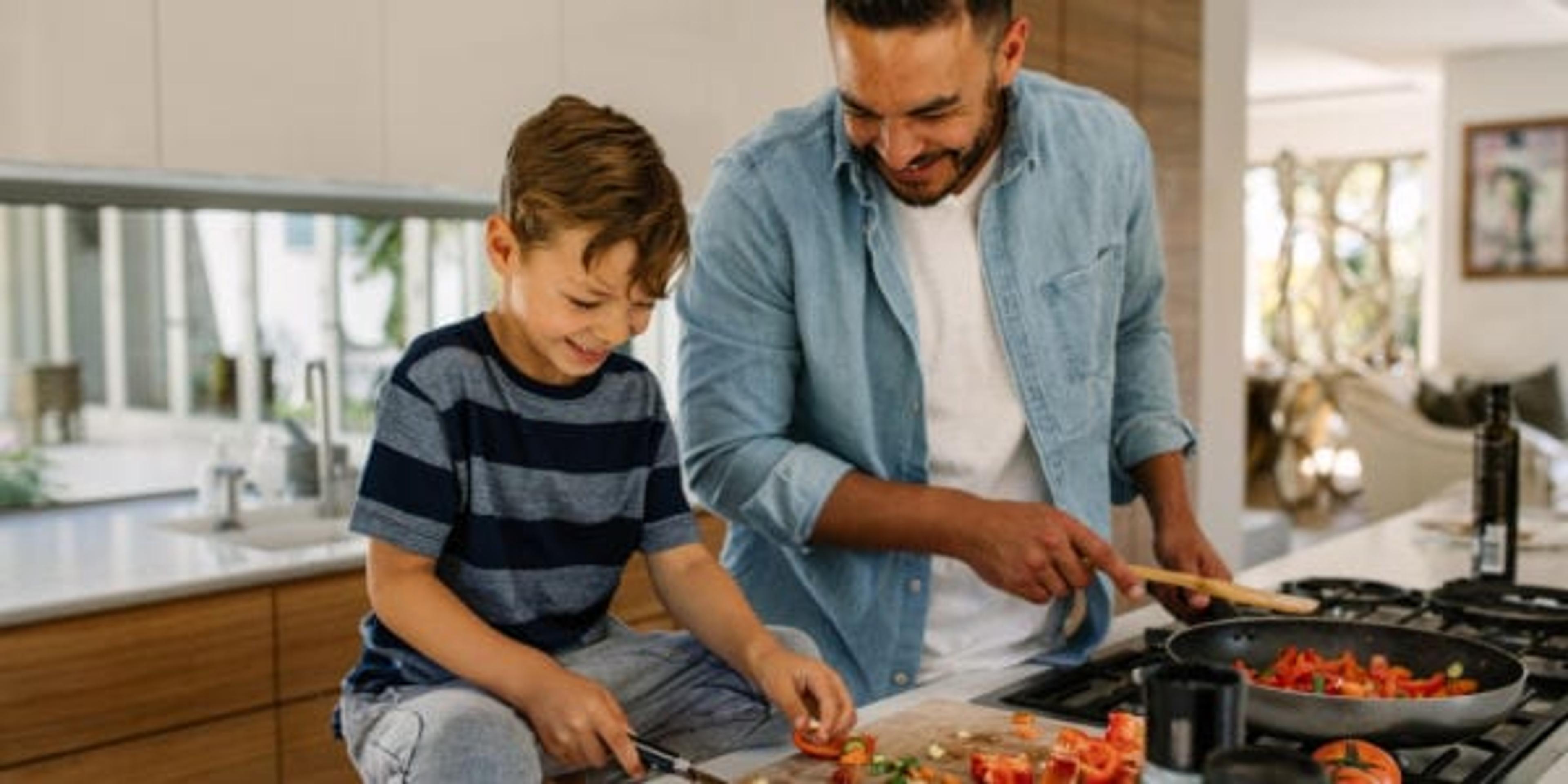 Image of a dad making dinner with his son.