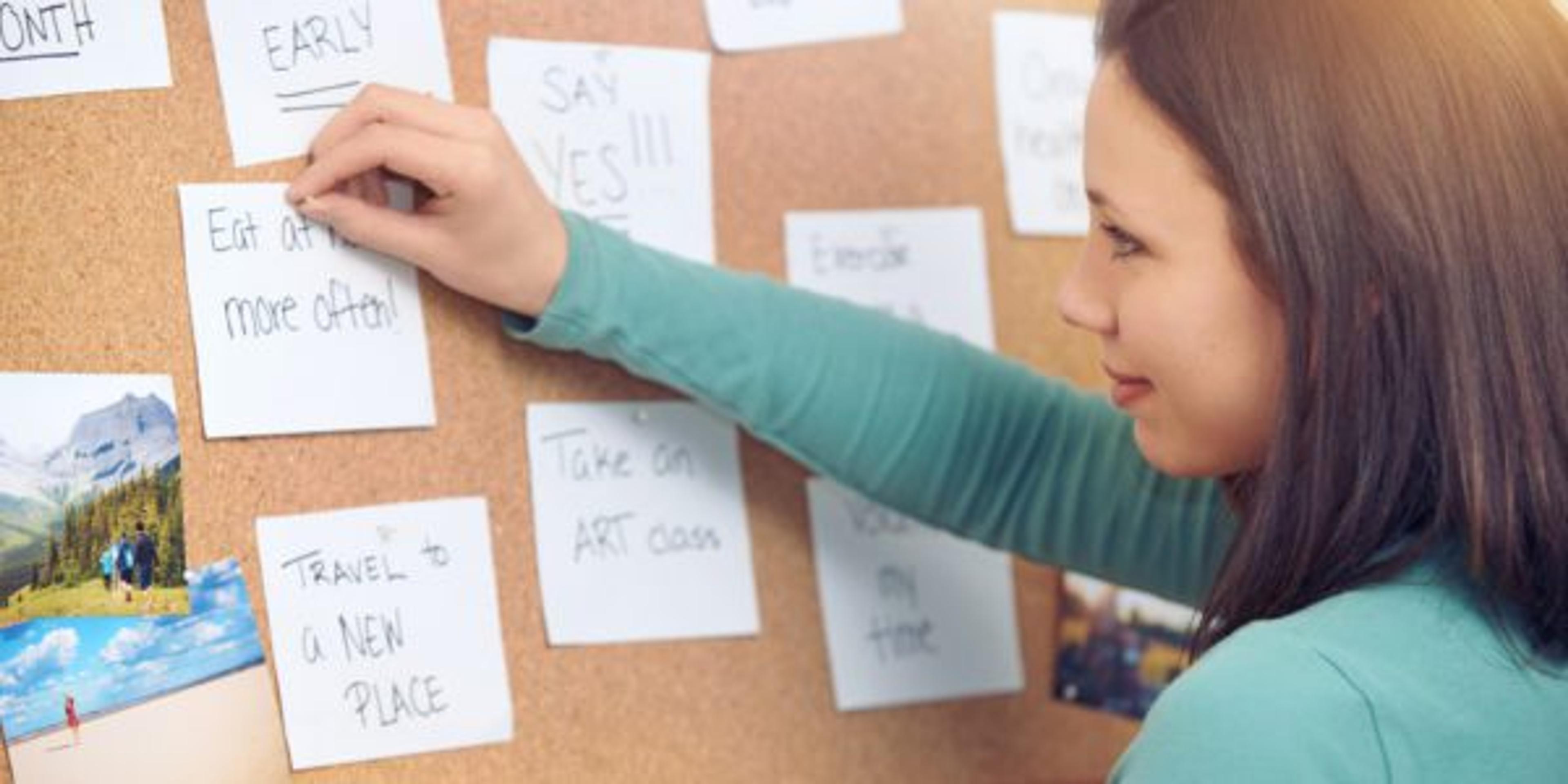 Woman pins notes to an inspiration board