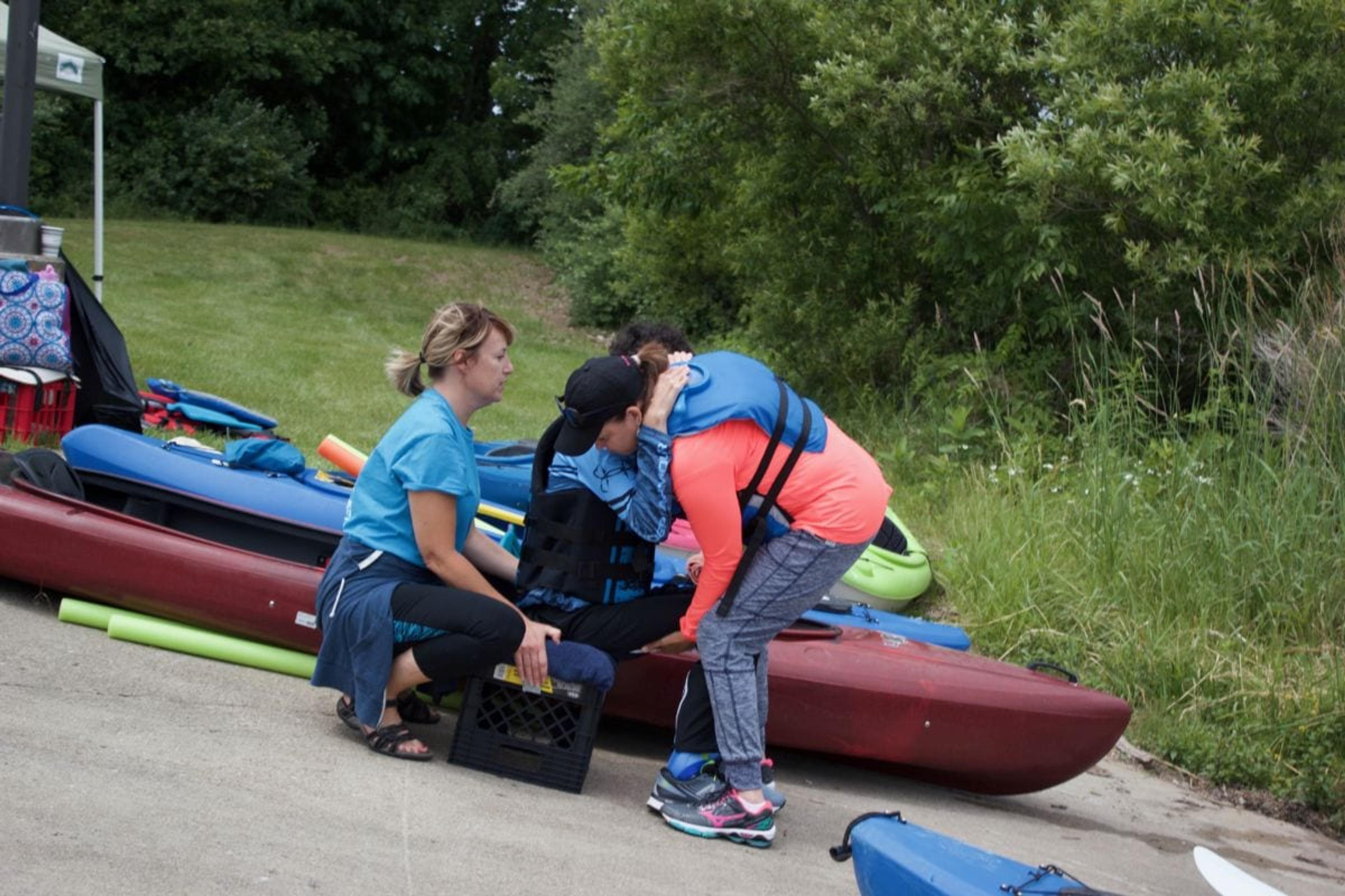 Helping boy get into kayak