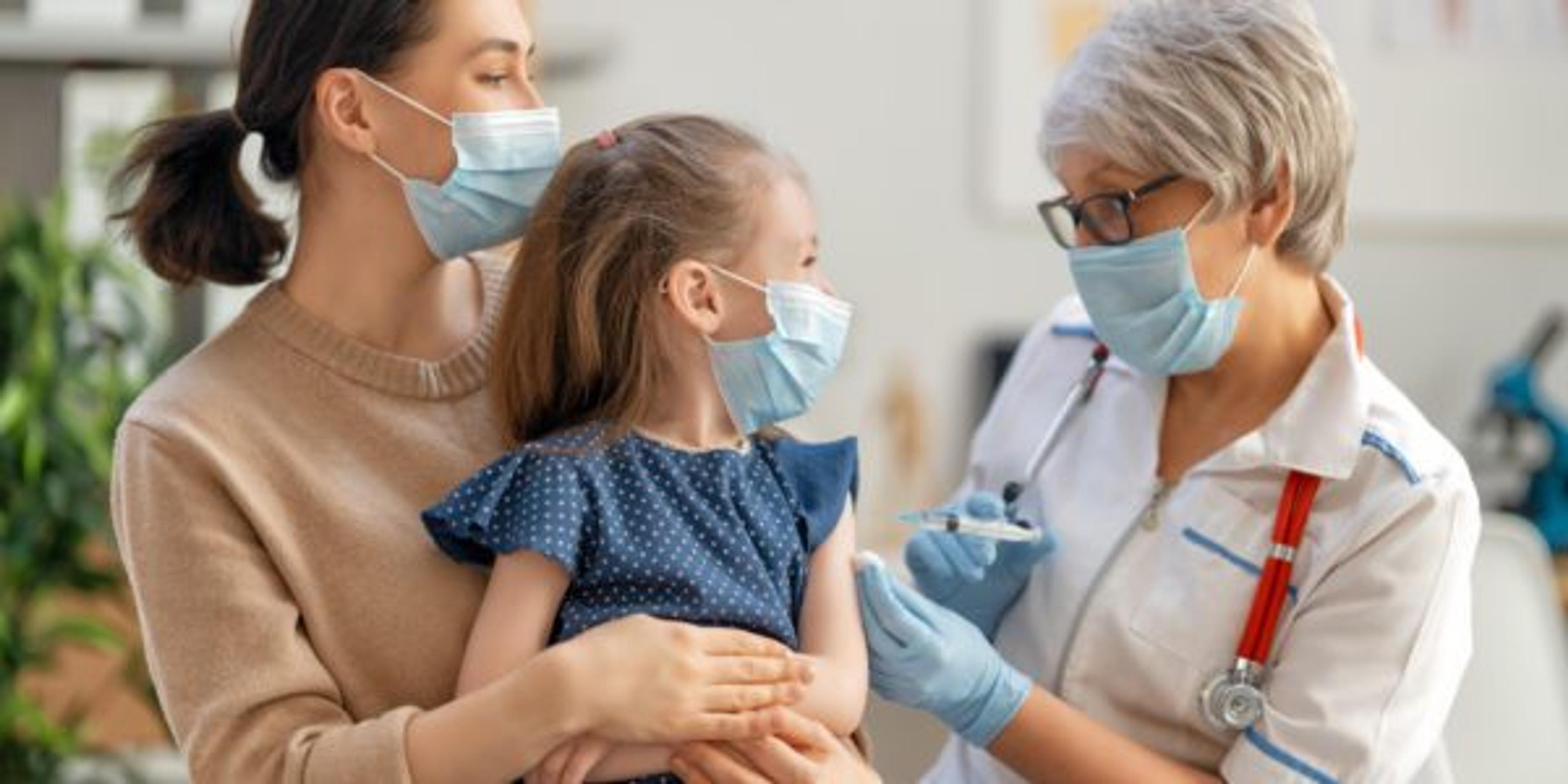 Doctor vaccinating child, kid with mother at hospital.