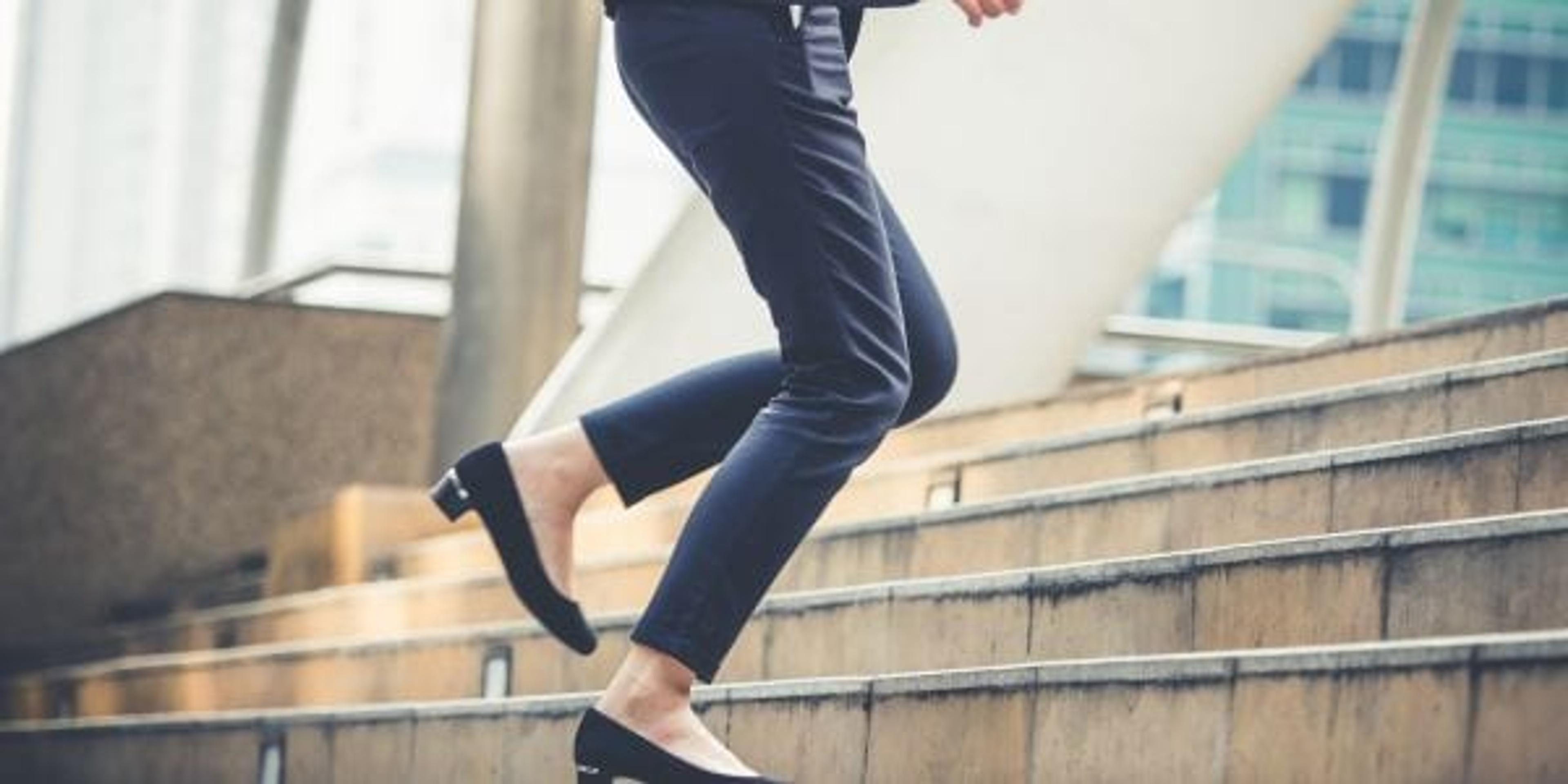 Woman in business clothes walking up stairs