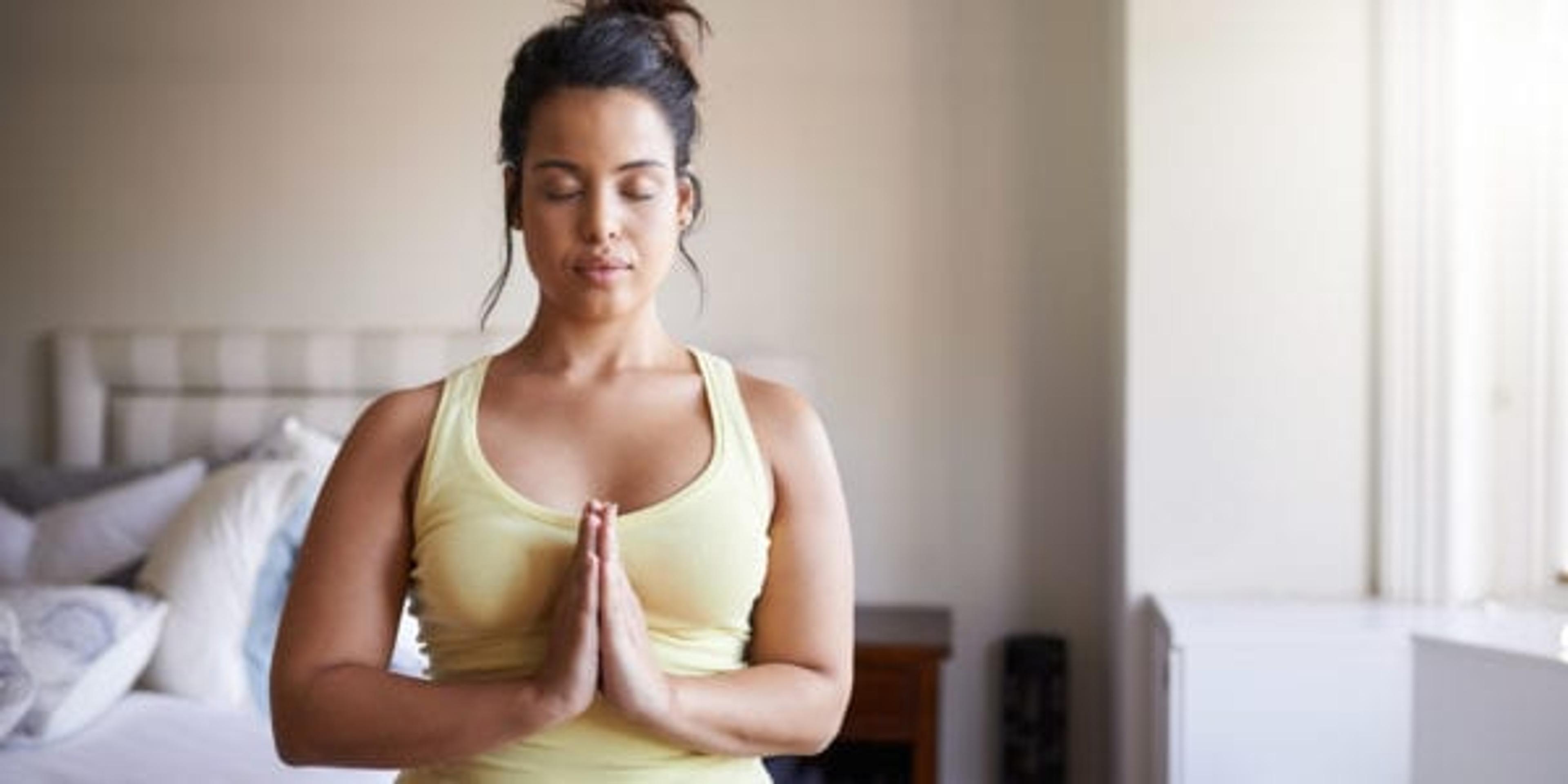 Shot of a beautiful young woman practicing yoga at home