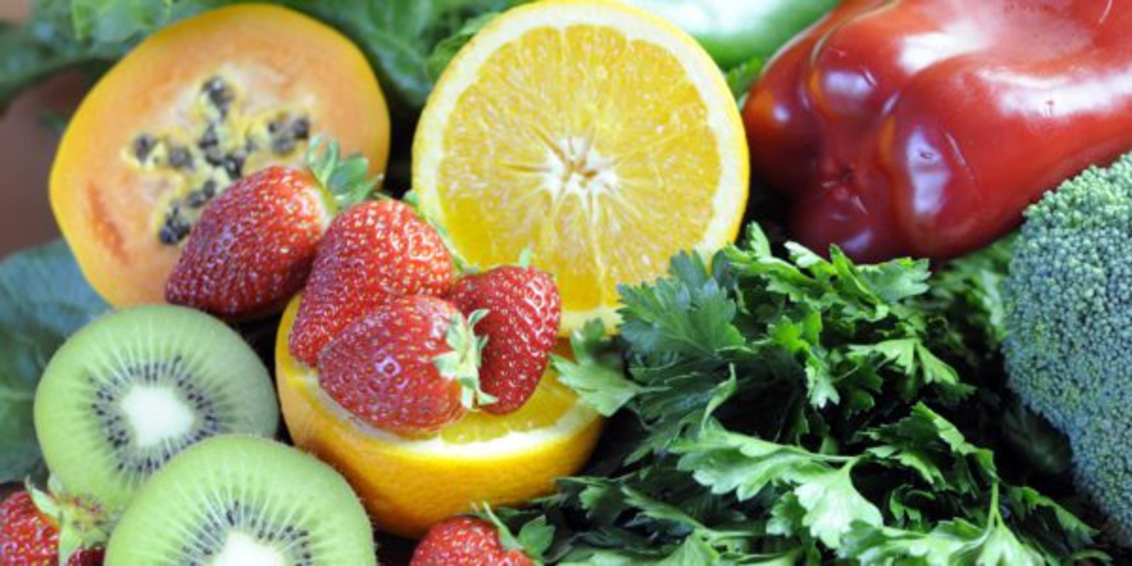 A countertop full of fruits and vegetables.