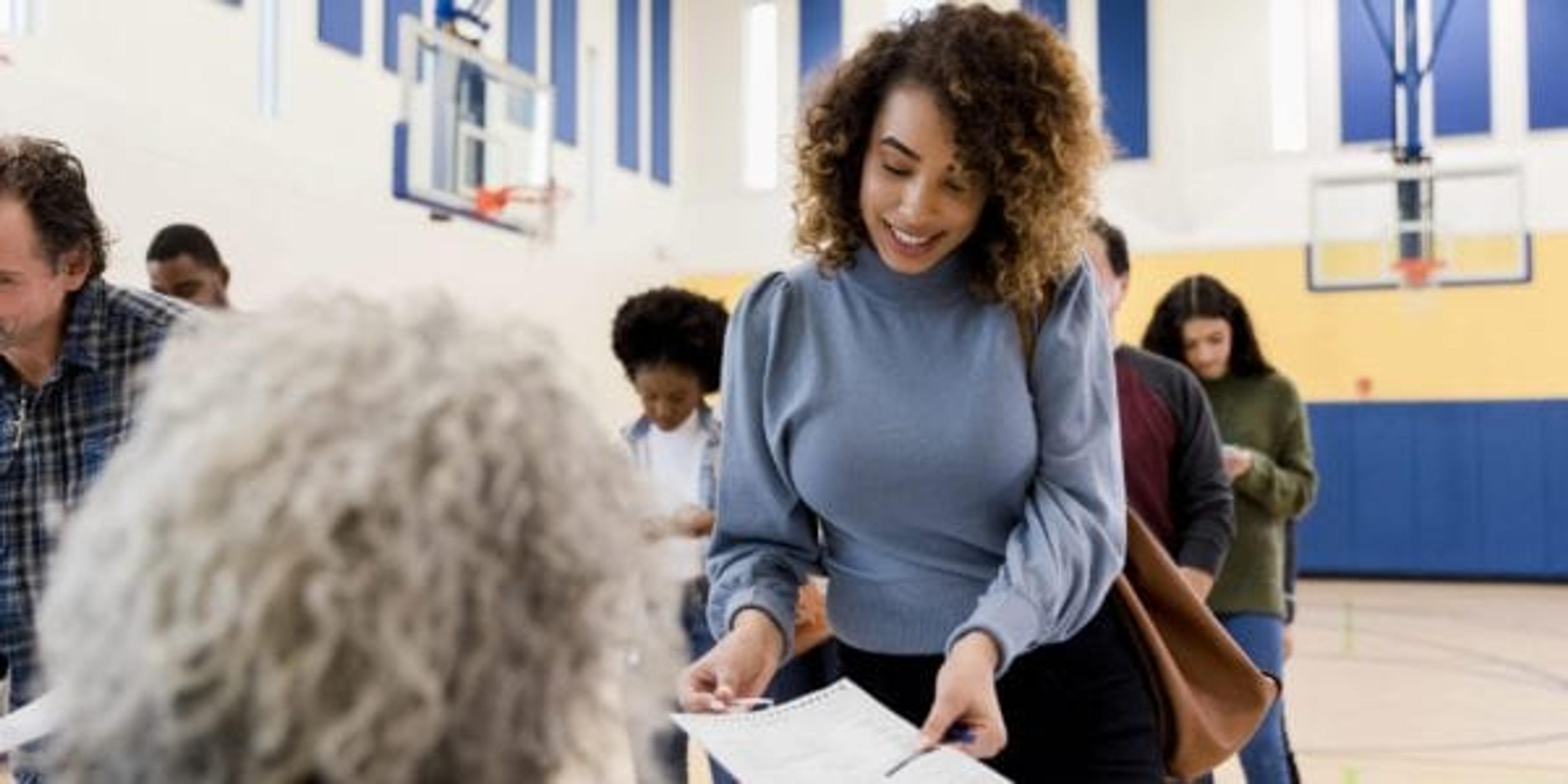 Woman voting in gymnasium