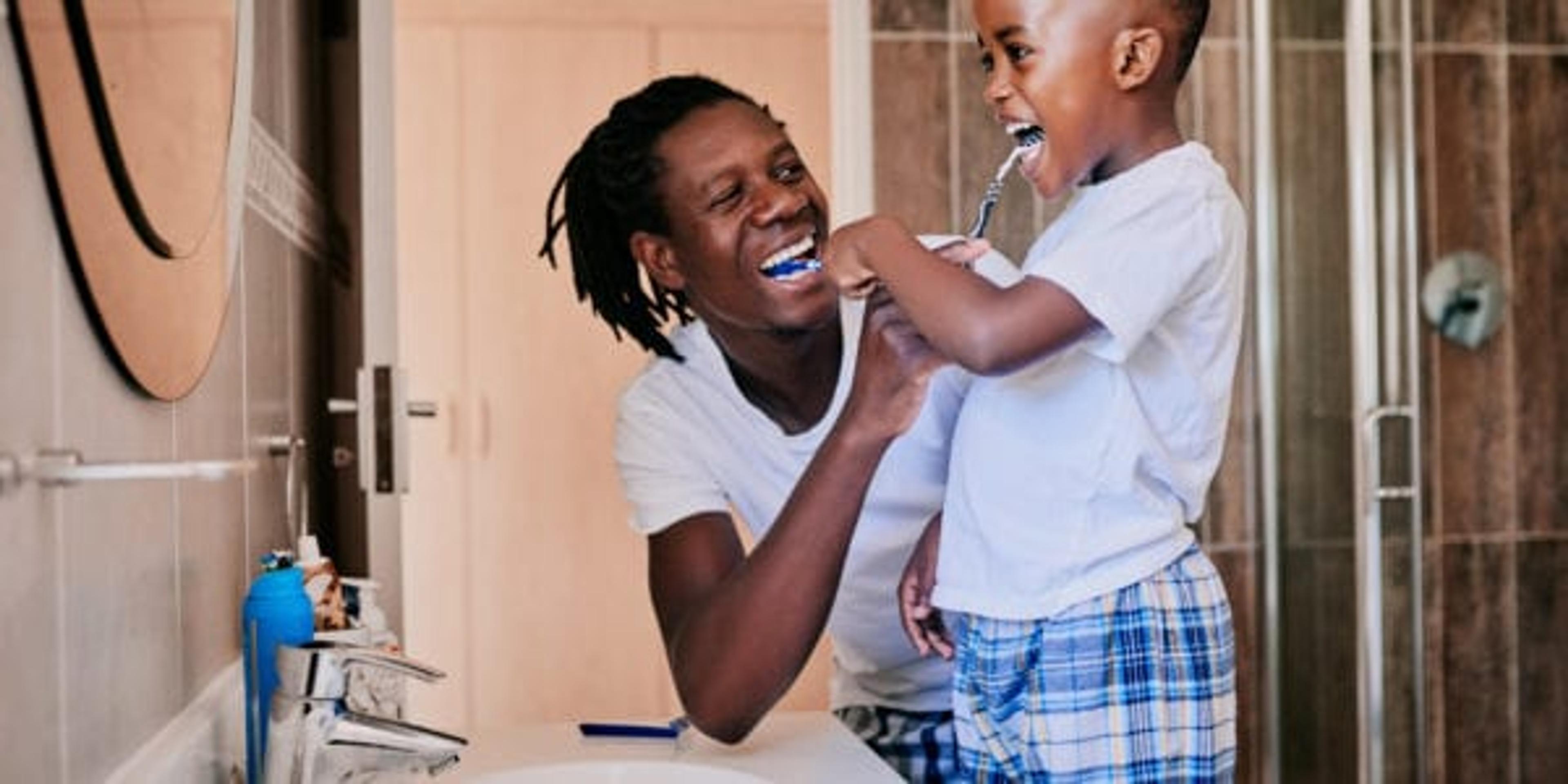 Cropped shot of a young man and his son brushing their teeth in the bathroom at home