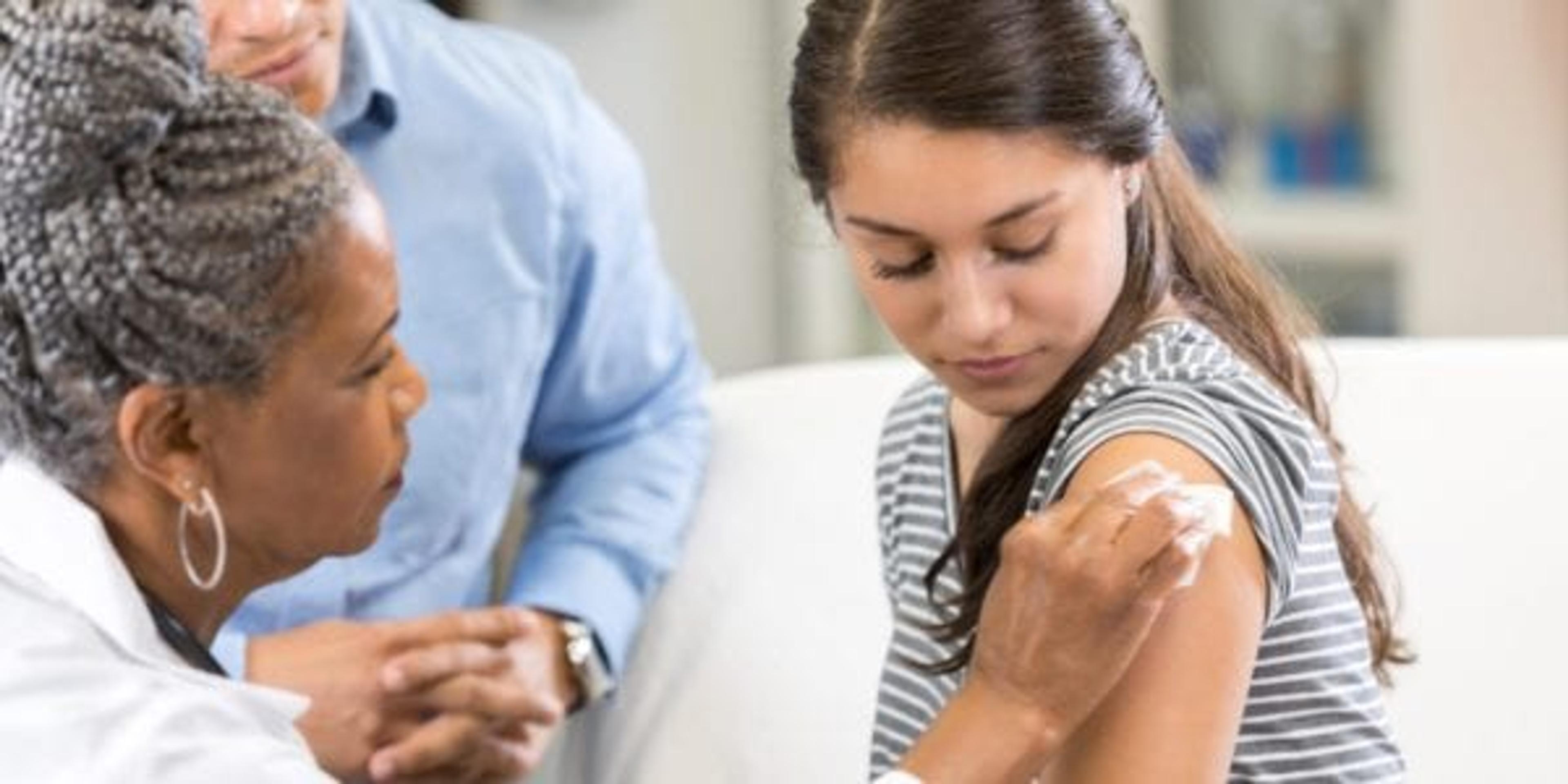 Teenage girl prepares for vaccination at doctor