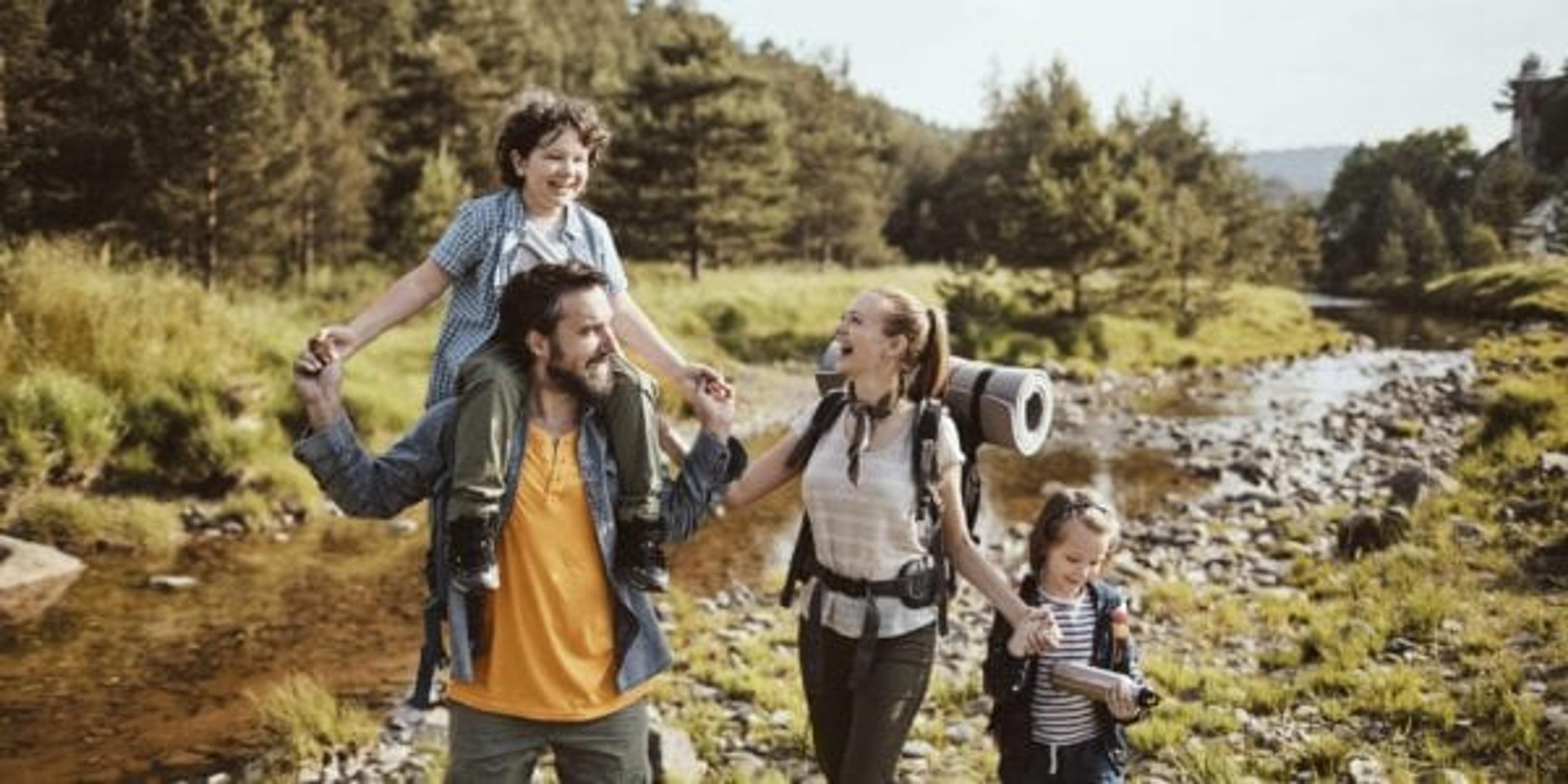 family hiking on trail in the woods