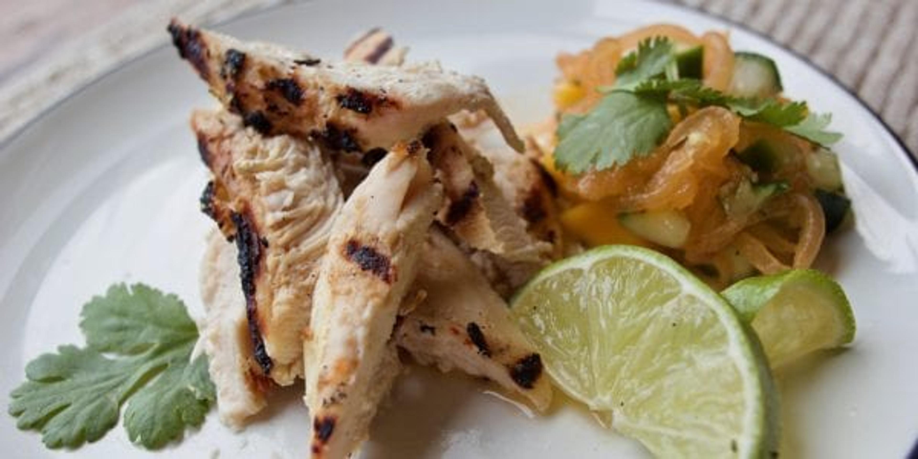 Grilled chicken on a plate with slaw.