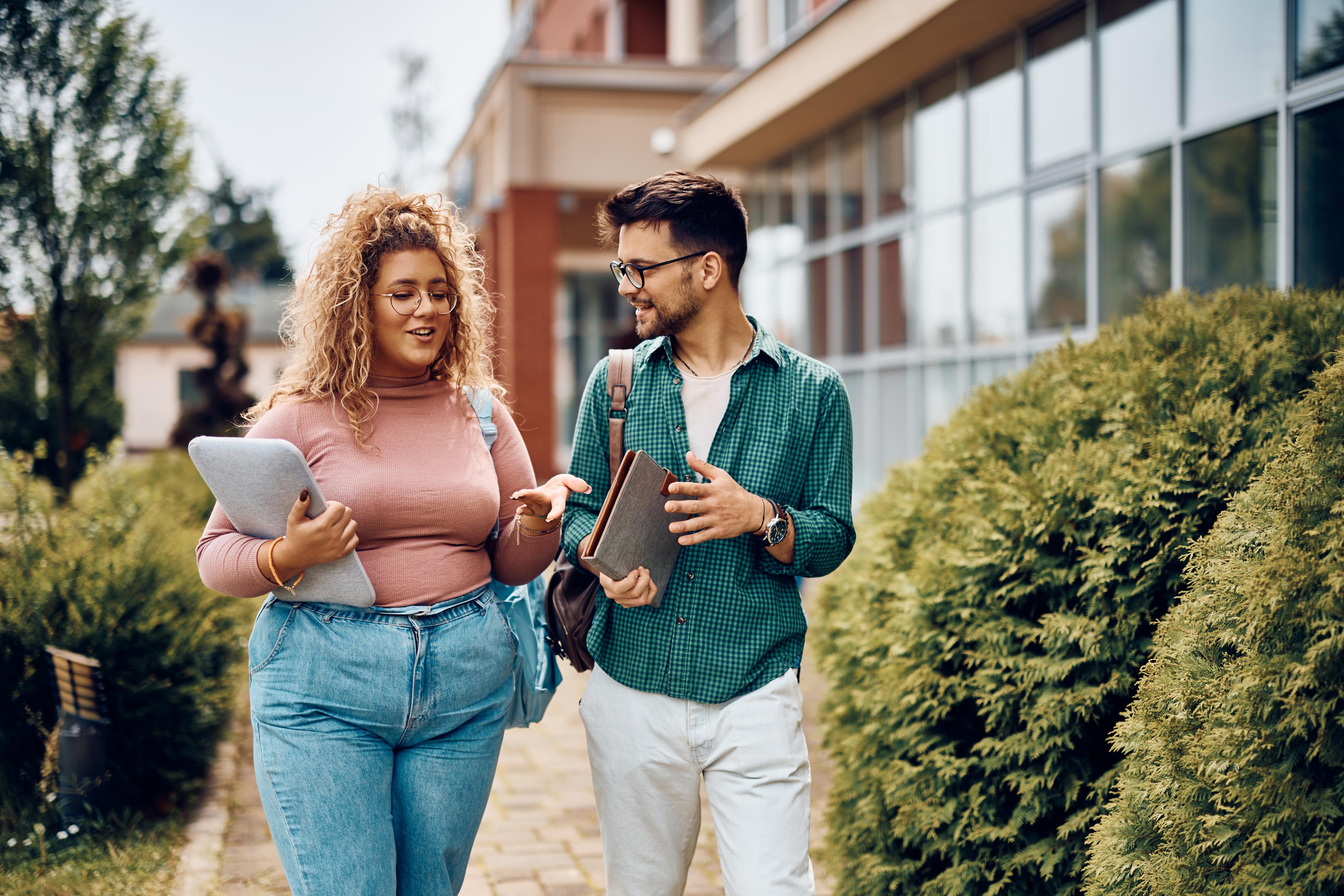 Male and female friends walk together between classes in college.