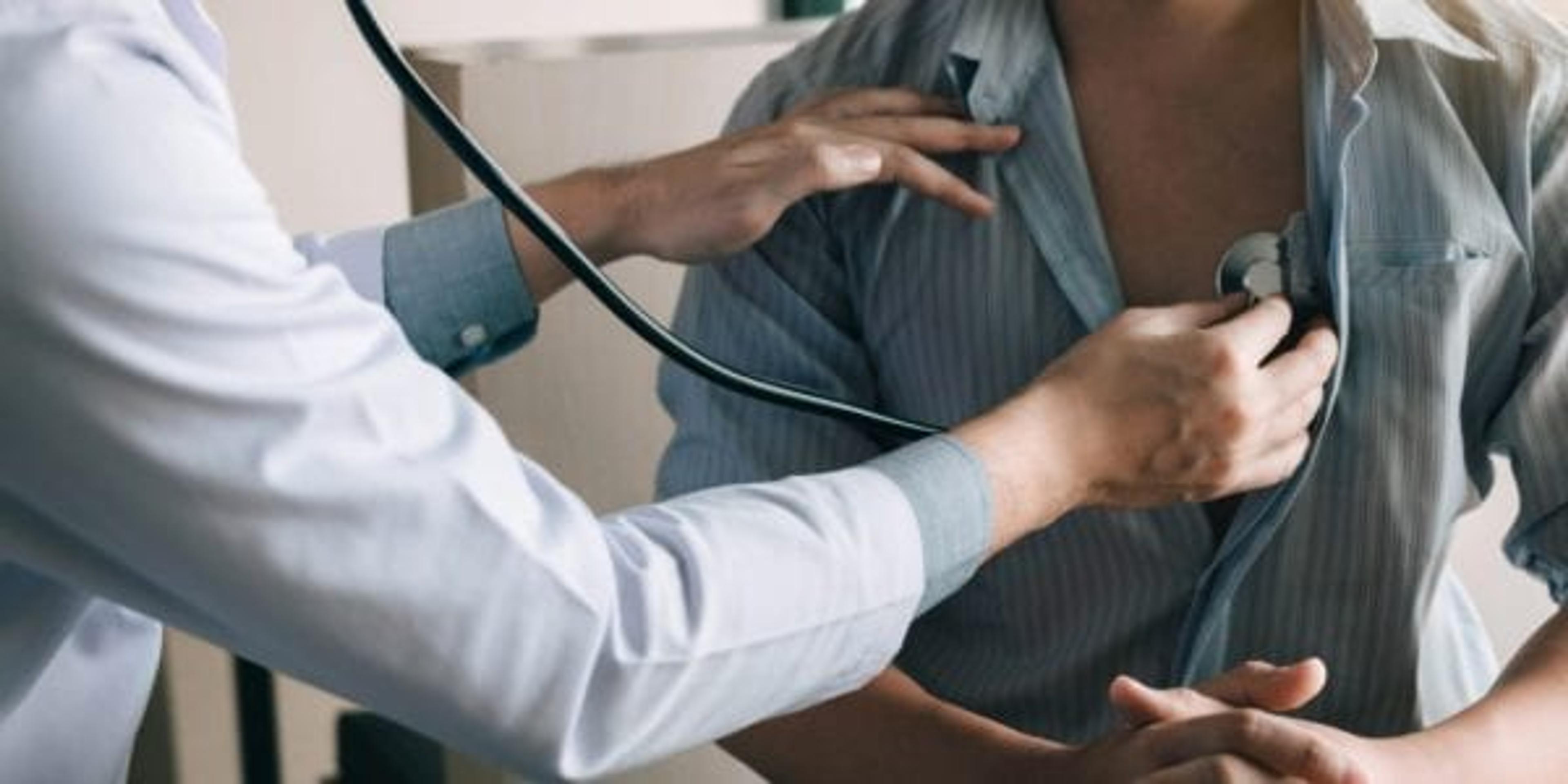 Asian doctor is using a stethoscope to listen to the heartbeat of an elderly patient.