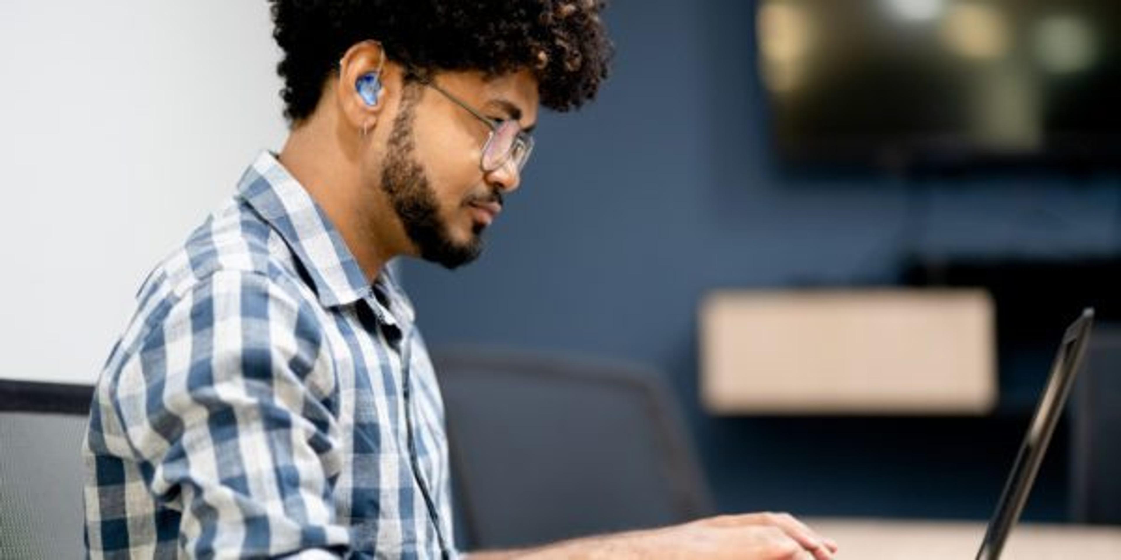 Hearing impaired man working on laptop at office