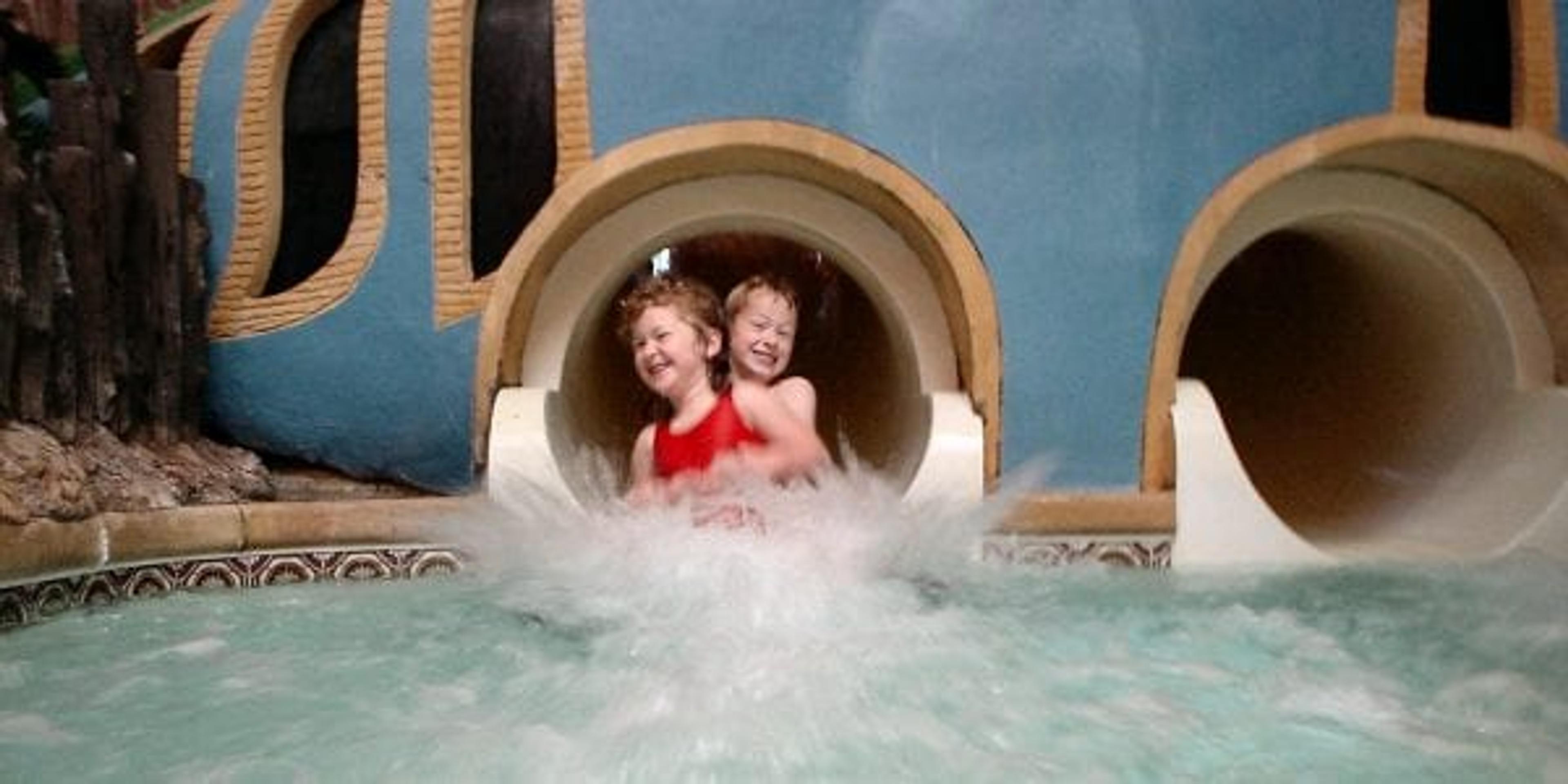 Two kids coming down a water slide