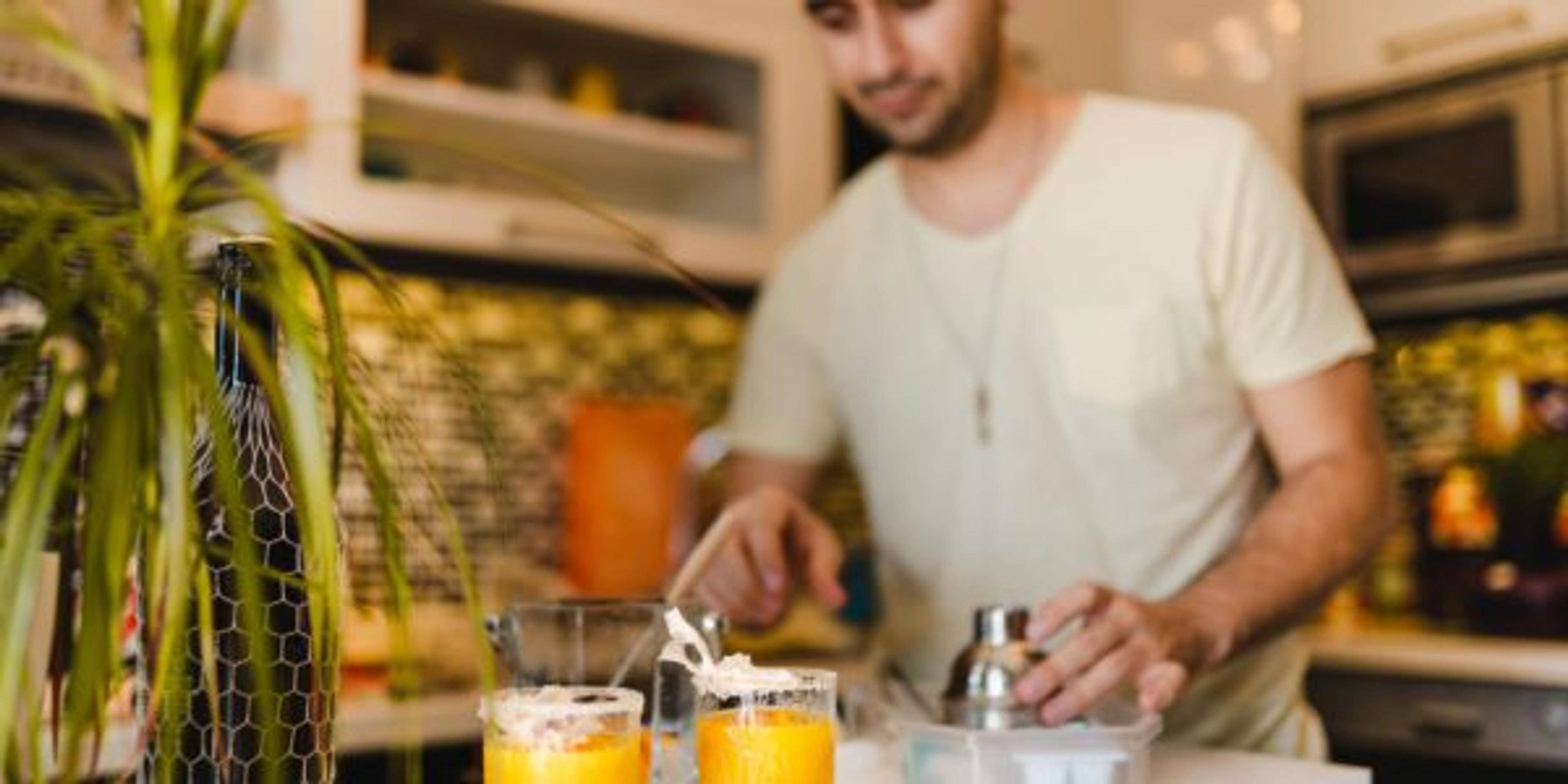 Young Adult Making Cocktails and having fun at Home
