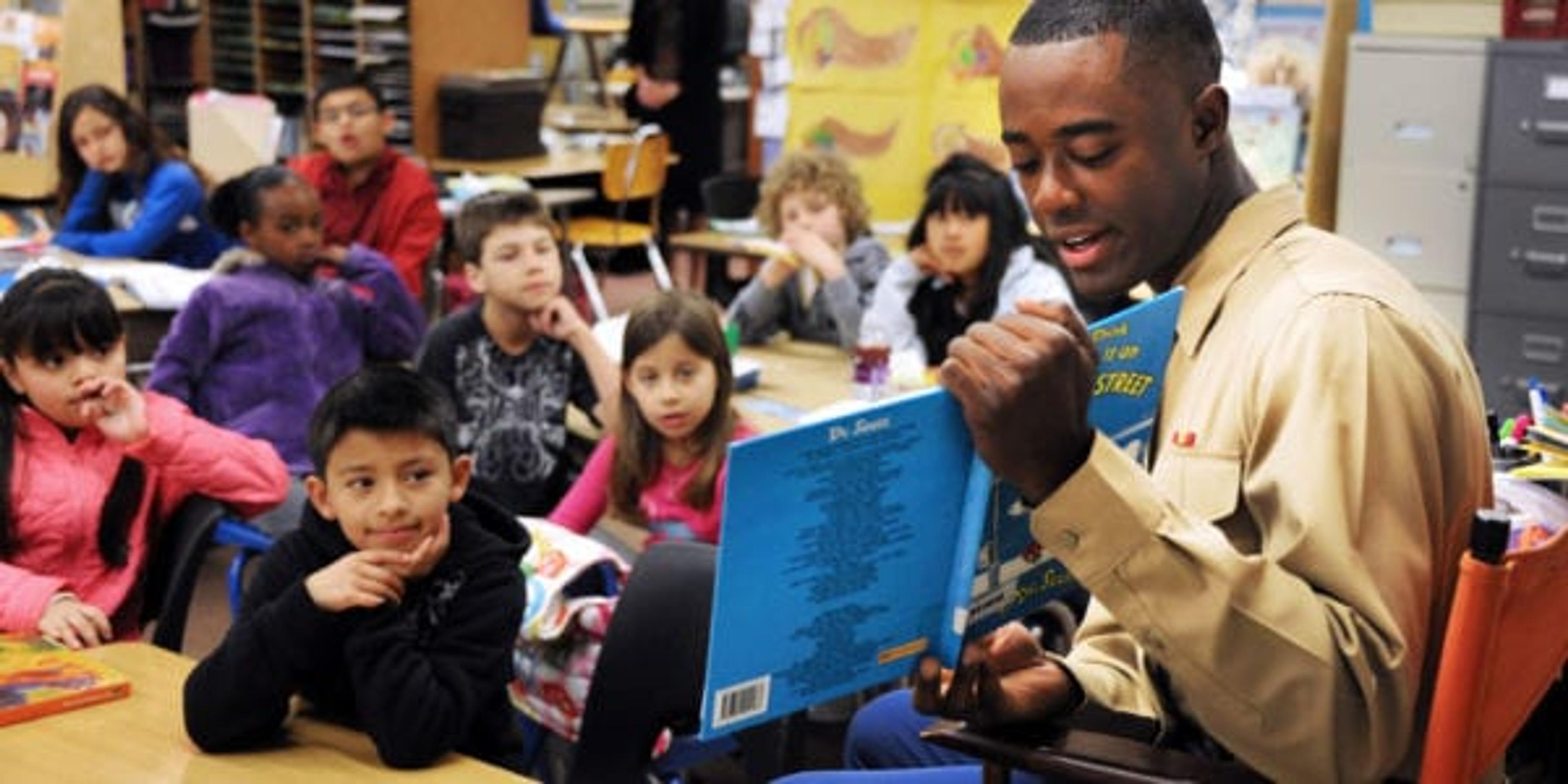 Man reading to a classroom of kids.