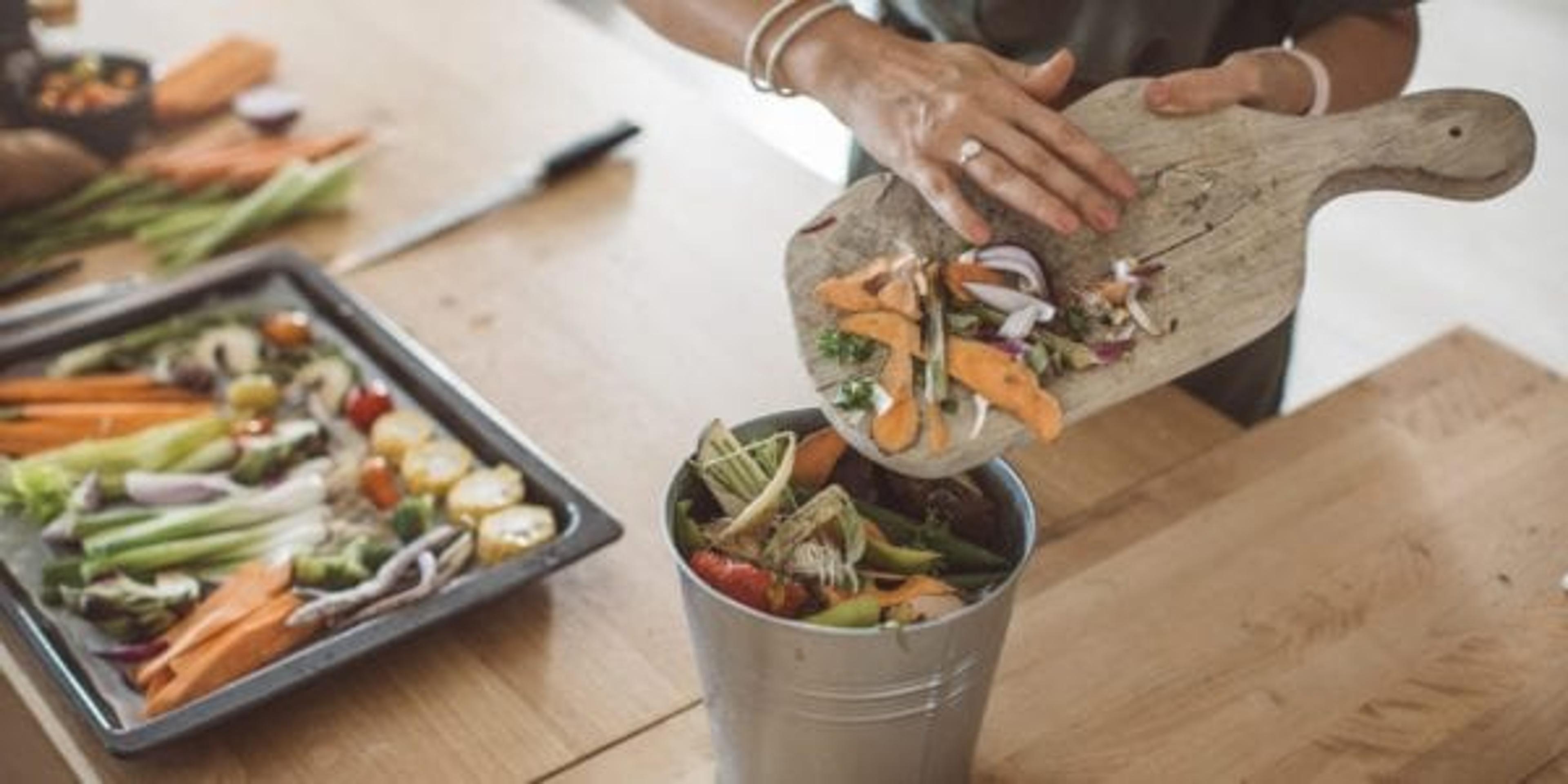 Scraping scraps into a compost pile