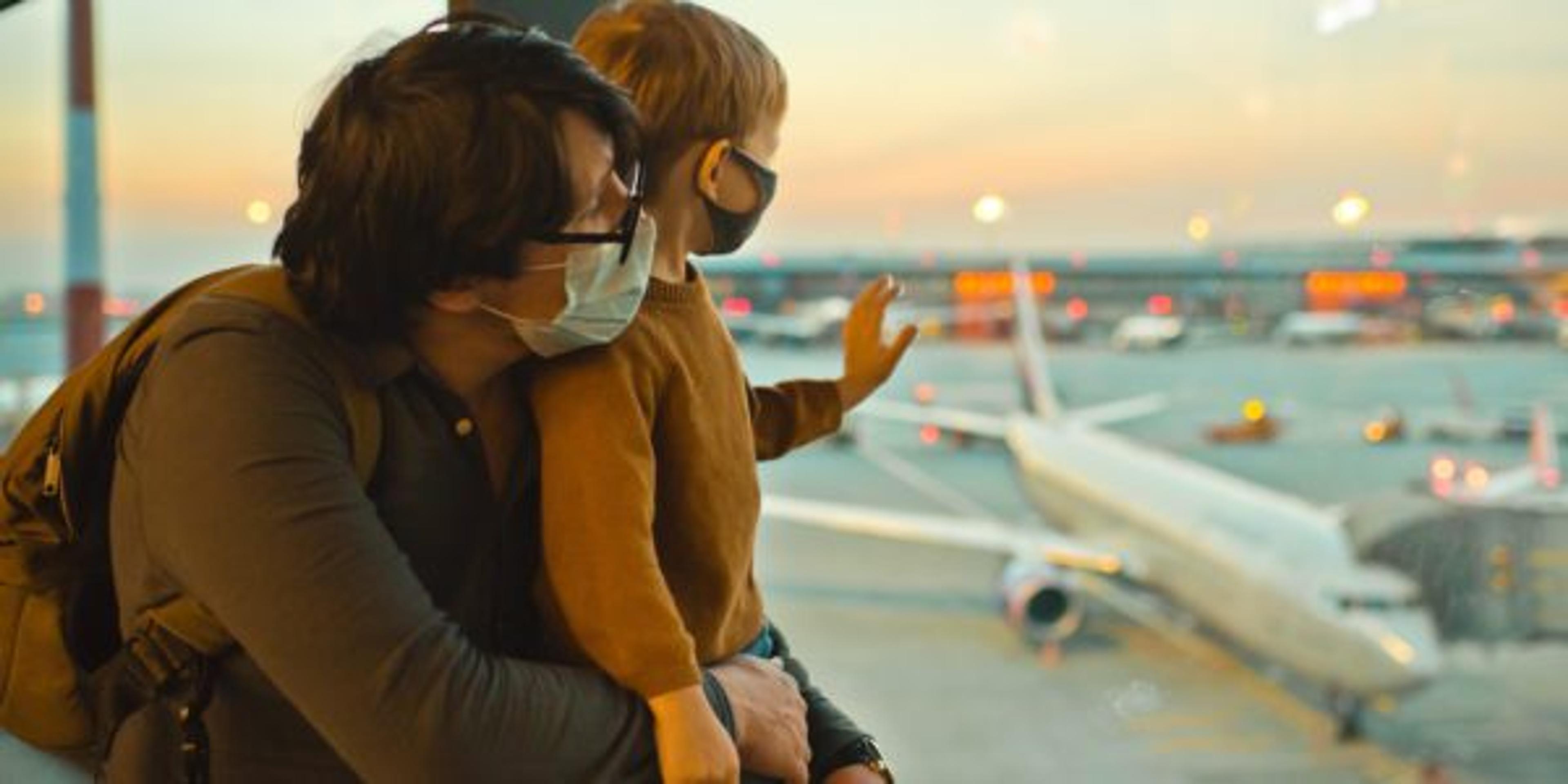 Family in protective face masks in airport during COVID-19 pandemic