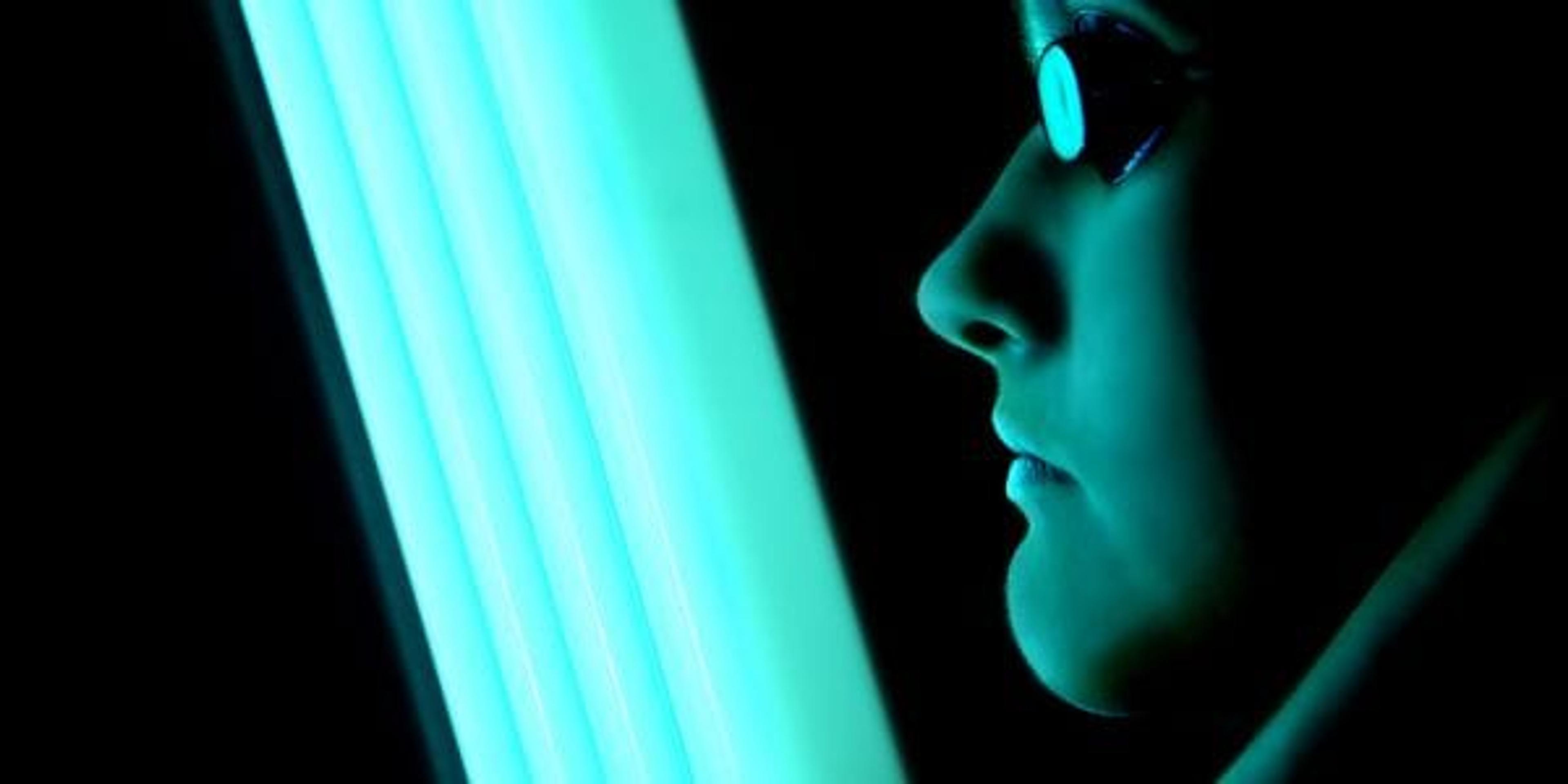 Woman in front of a facial tanning light